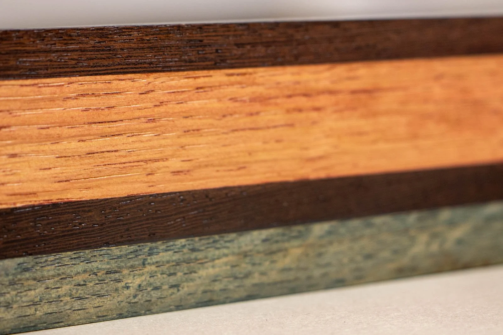 Silence’s Caesura 002 frame: long side, fine-pored wengé top rail over a broad mahogany ribbon; steady grain in the oak foot