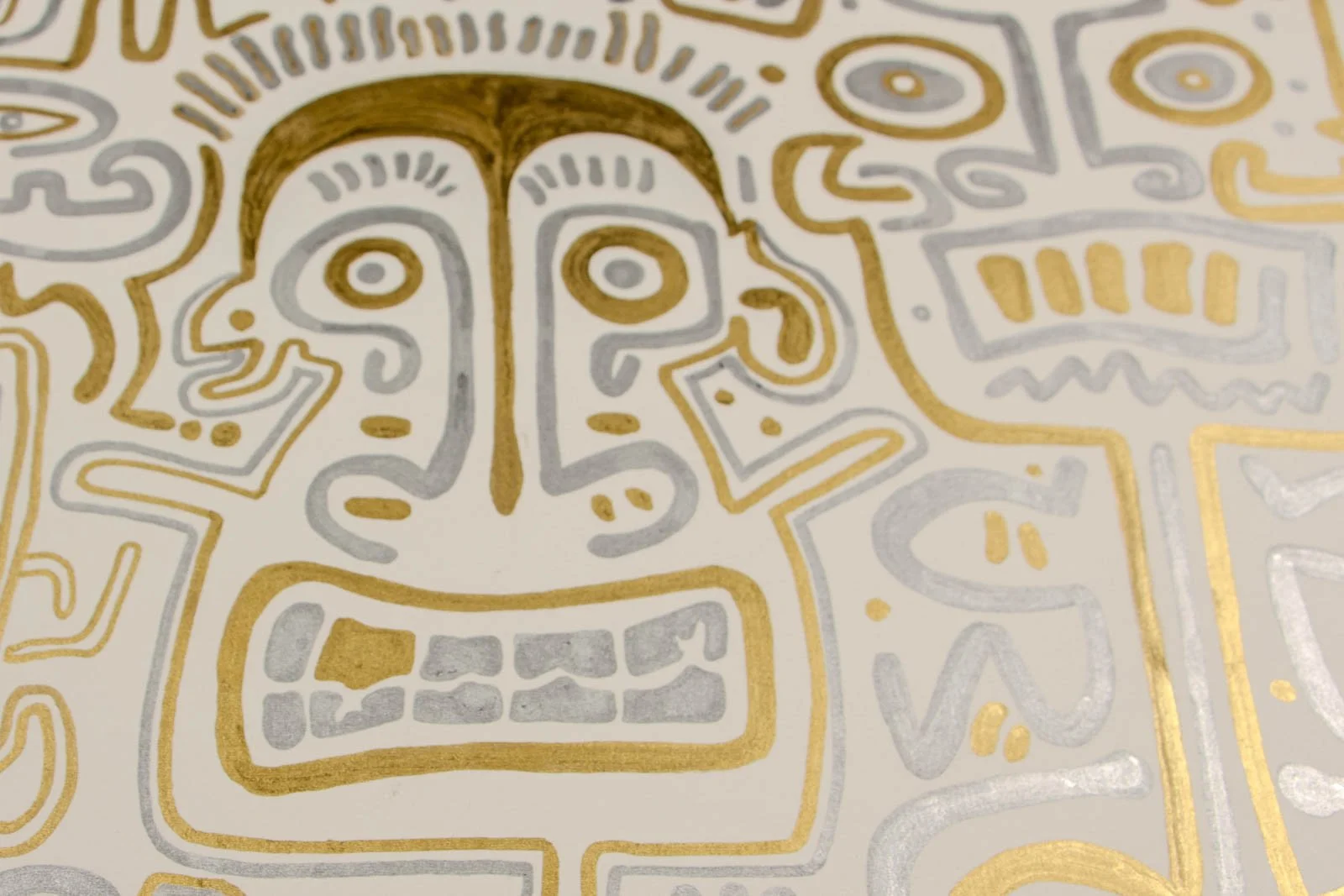 Golden Nostalgia 003 detail: central visage, arched gold brow framing wide-set eyes; silver underlayer and squared teeth; metallic sheen over warm ivory paper