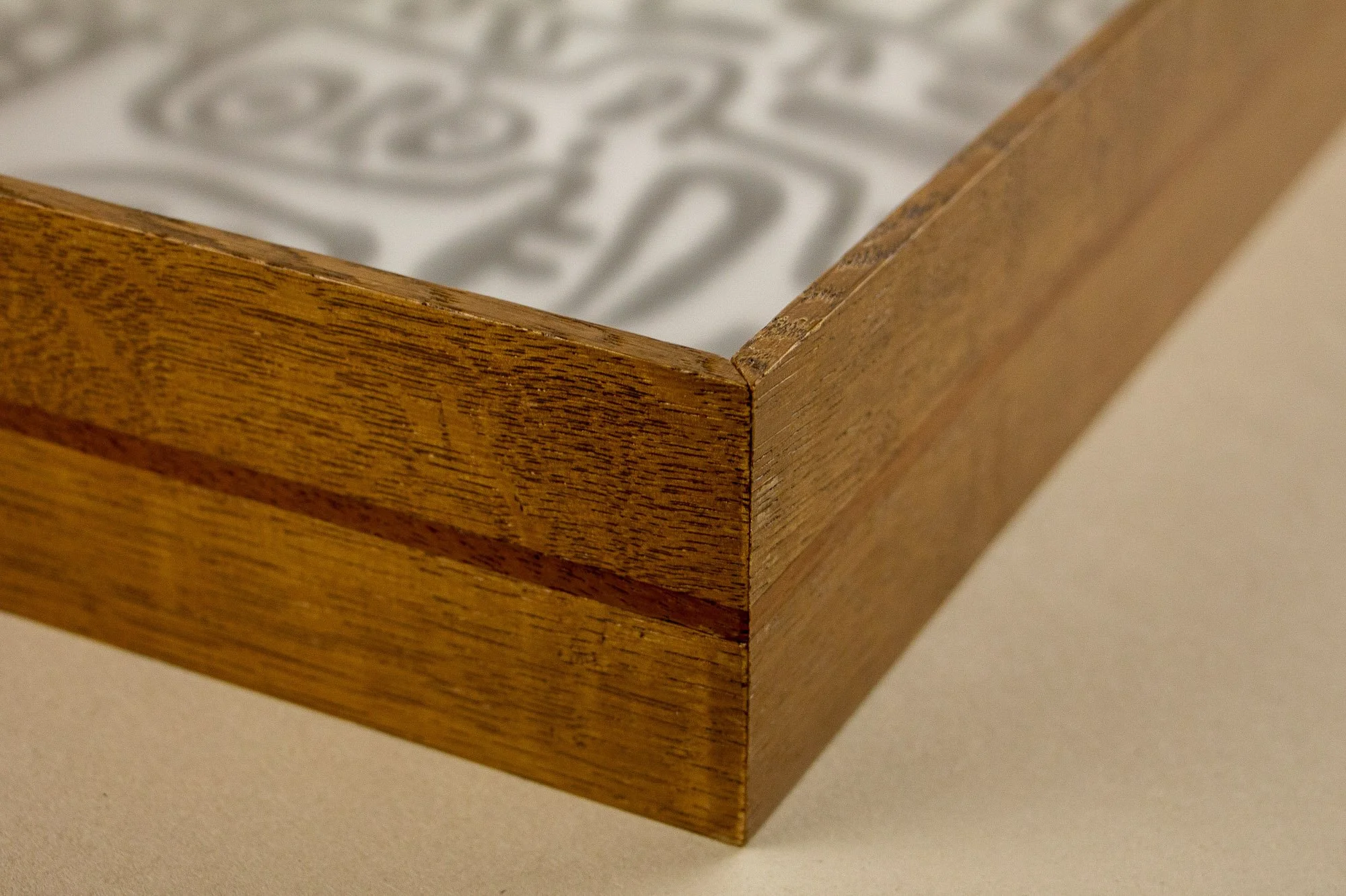 Veiled Alchemist 003 frame detail: close-up along the frame edge, highlighting the layered wood construction, the subtle tonal shifts in the grain, and the quiet linear accent of the slim inner band.