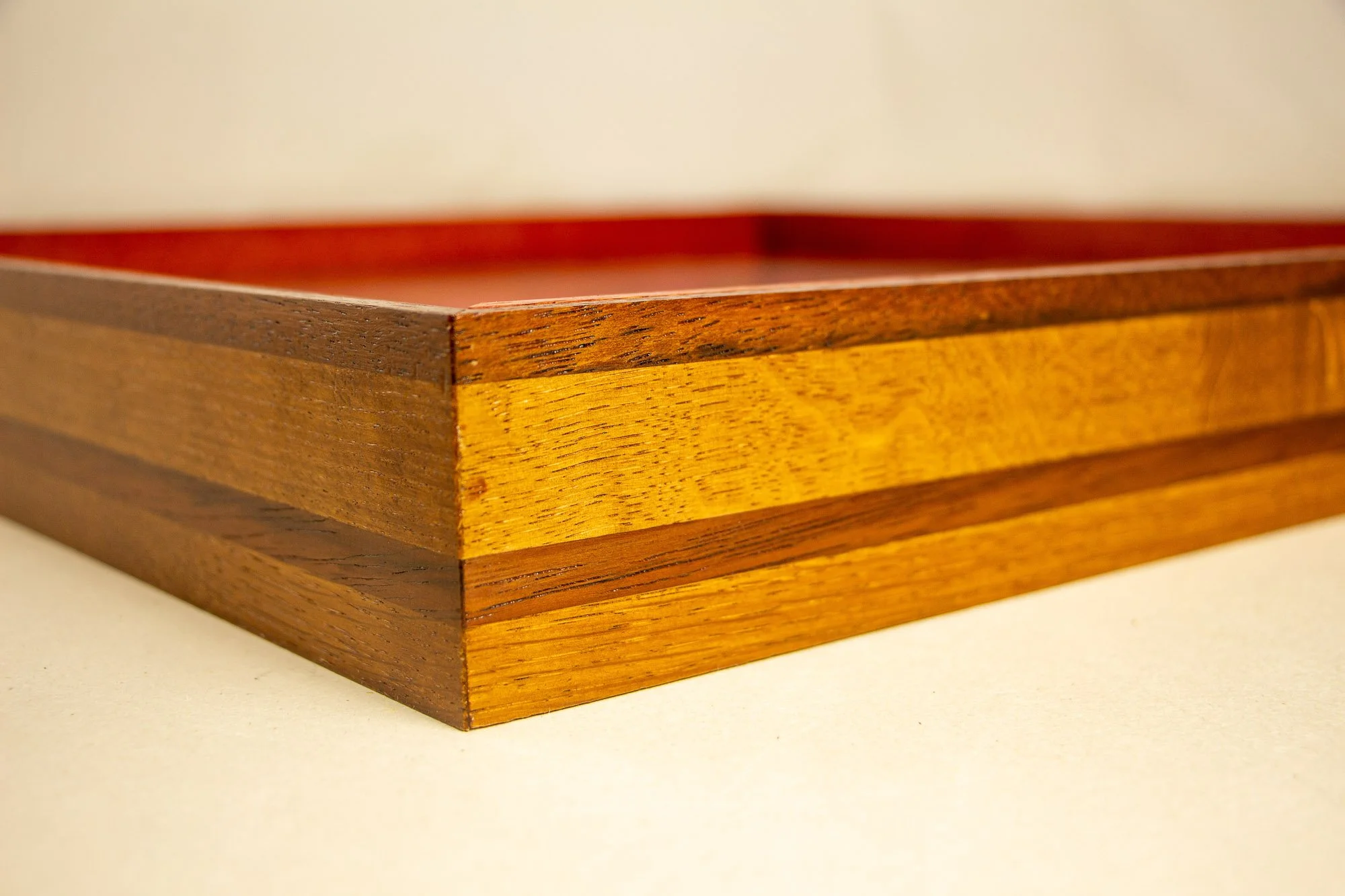 Unseen Signifiers 008 frame detail: angled close-up of the mitered corner, showing the layered golden-brown and darker brown wood strips meeting cleanly at the frame edge. mahogany, oak and beech wood.