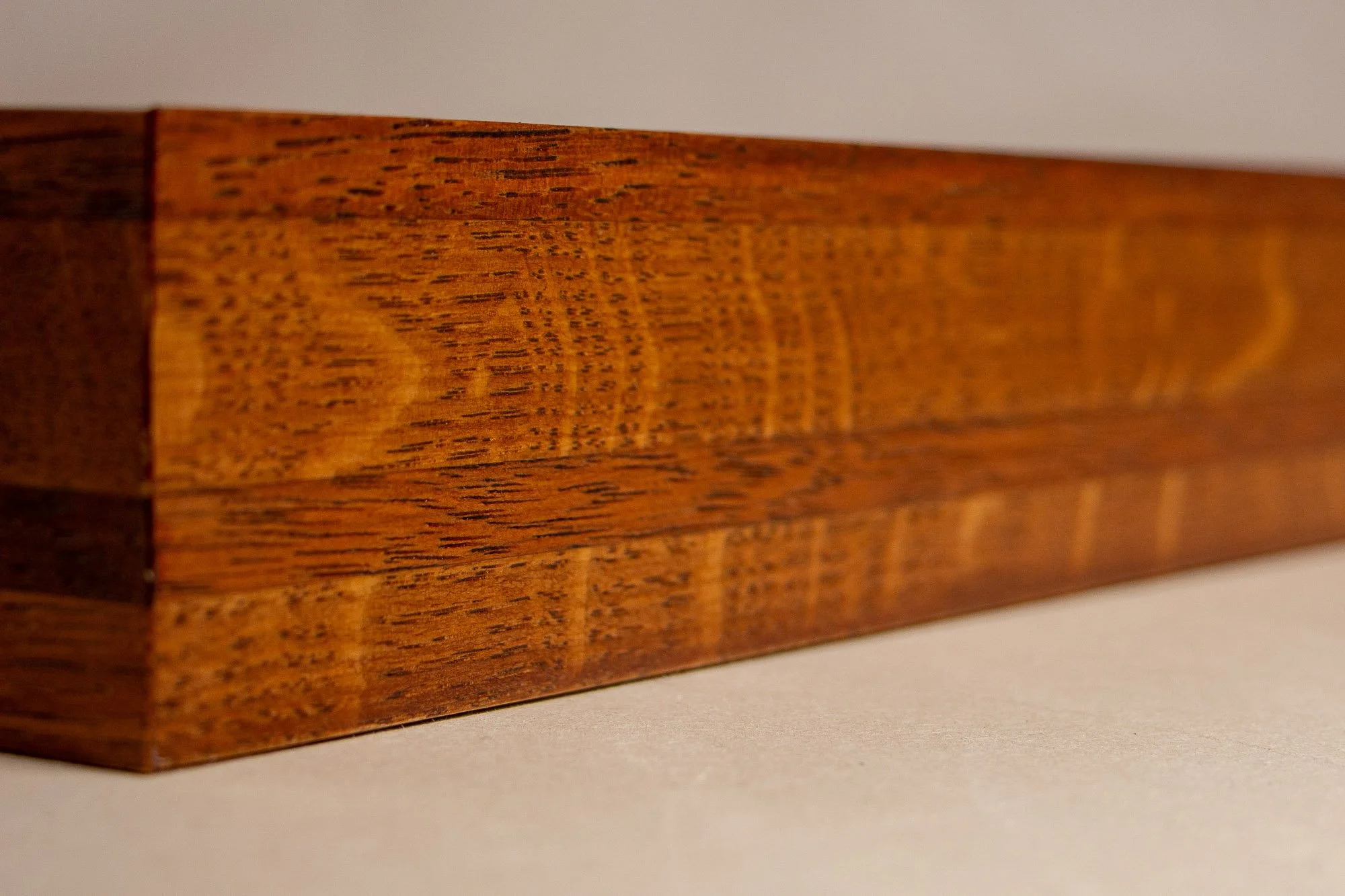 Turbulent Aegis 001 frame detail: oblique side close-up of the frame body, showing the elongated grain pattern, layered construction, and polished handcrafted finish.