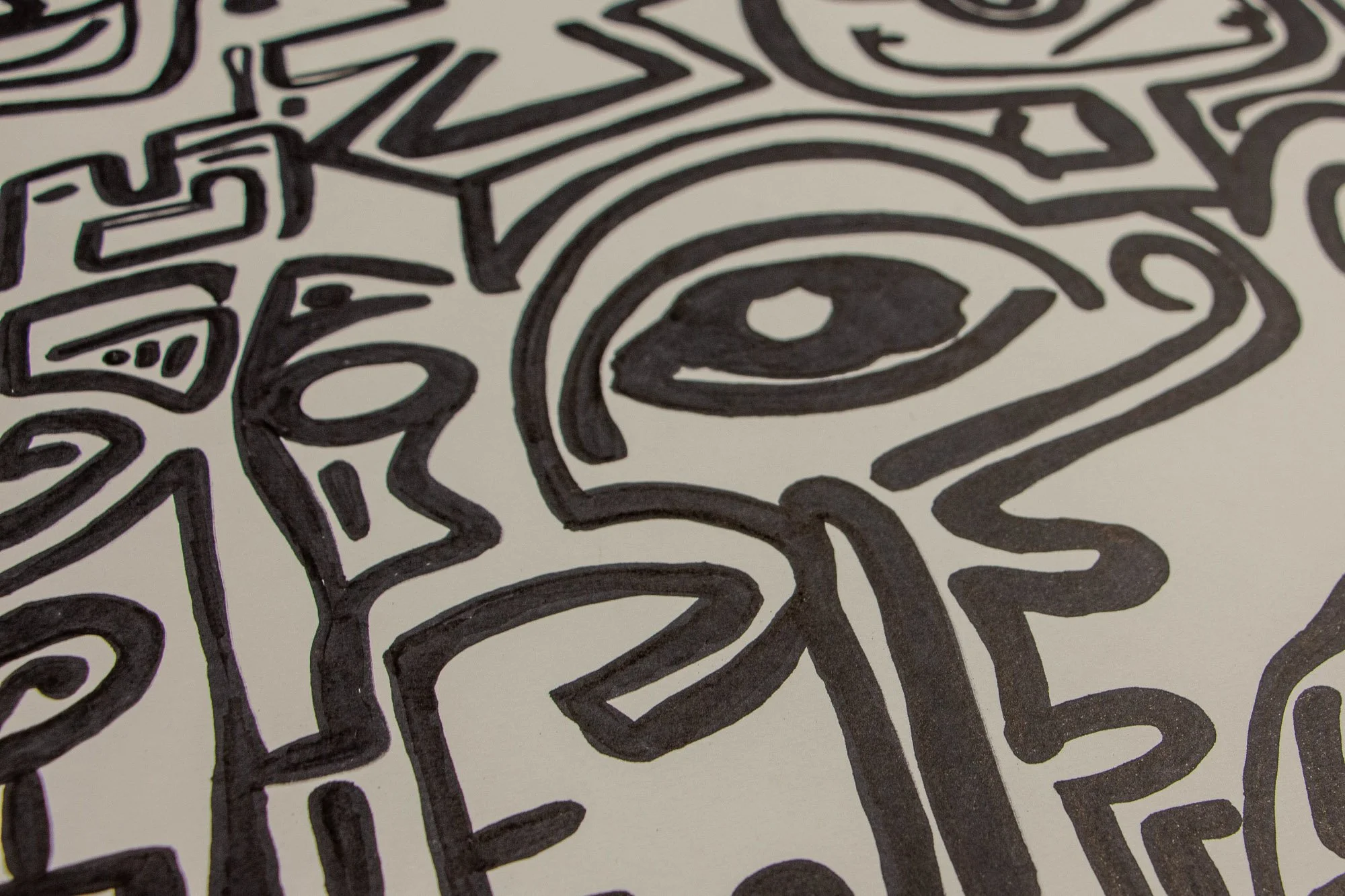 Elusive Cocoon 003 detail: upper section detail with a flower-like circular motif, a row of short vertical marks, stepped angular forms, and a single eye motif emerging from the surrounding black linework.