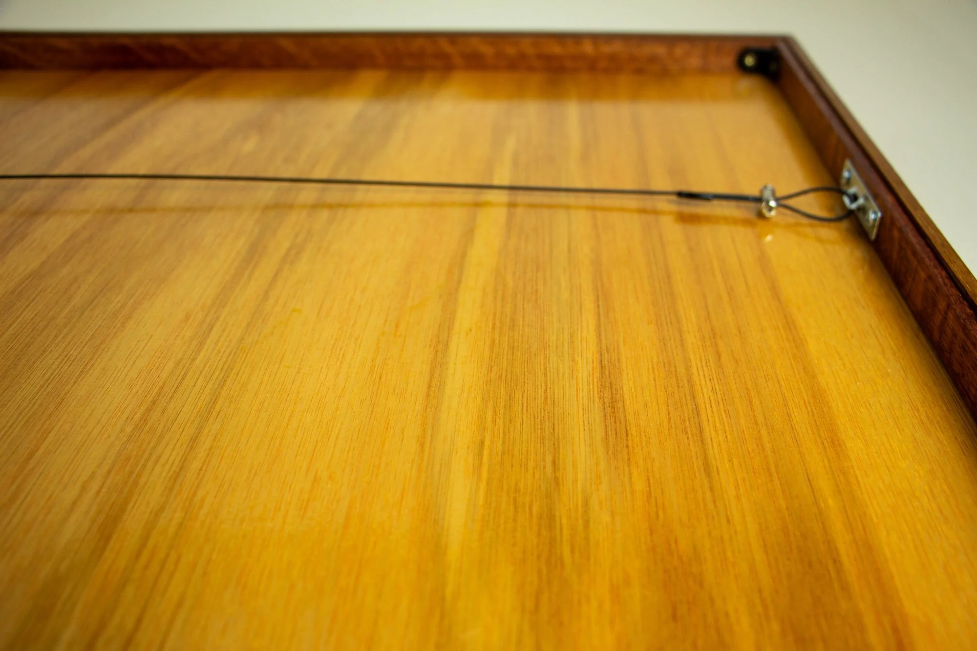 Unseen Signifiers 008 back detail: rear view of the frame showing the smooth wooden back panel and the black hanging cable attached across the reverse.