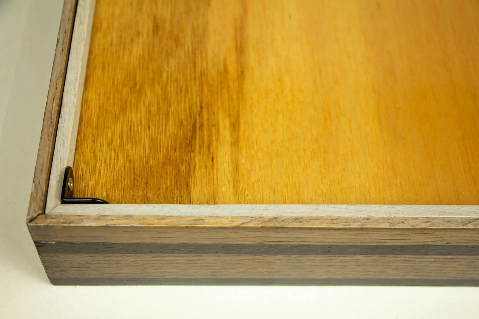 Synaptic Mythos 002 frame: back, inner corner, black L-bracket fixes the honey-toned backing panel to the frame