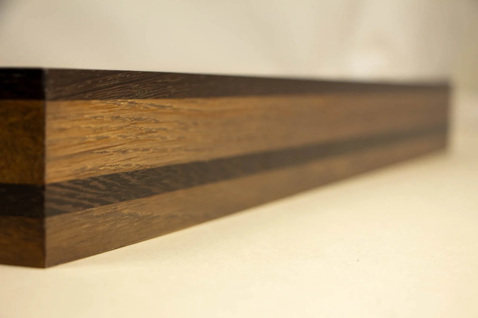 Synaptic Mythos 003 frame: long side elevation, expressive oak figure with a small cat-eye knot; upper wengé lip and mid band read clean