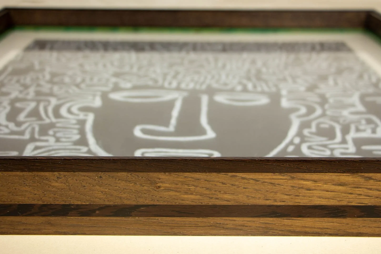 Synaptic Mythos 004 frame: low raking view, glass sits flush beneath a dark wengé cap; ash-stained oak body with twin wengé rails