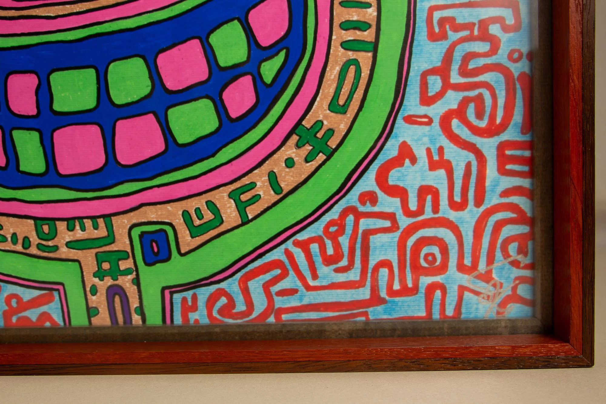 Unseen Signifiers 008 frame detail: lower-right corner detail of the artwork within the frame, showing the red inner edge, dark inner border, and silver signature on the pale blue ground. mahogany, oak and beech wood.