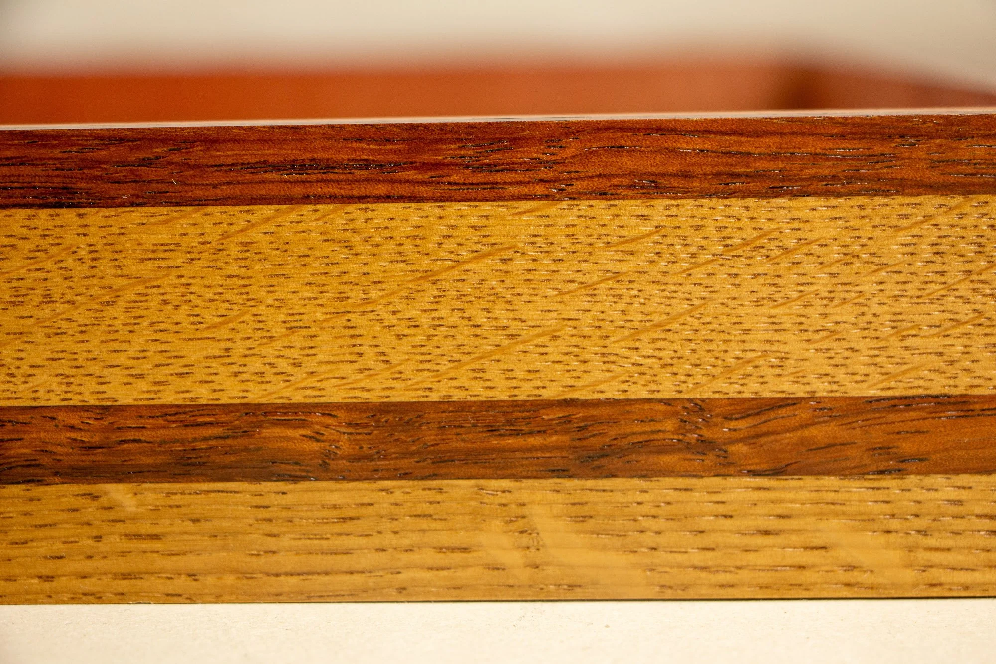 Unseen Signifiers 004 frame detail: frontal close-up of the striped side profile, emphasizing the contrast between the lighter golden wood and the darker reddish-brown bands. mahogany, oak and beech wood.