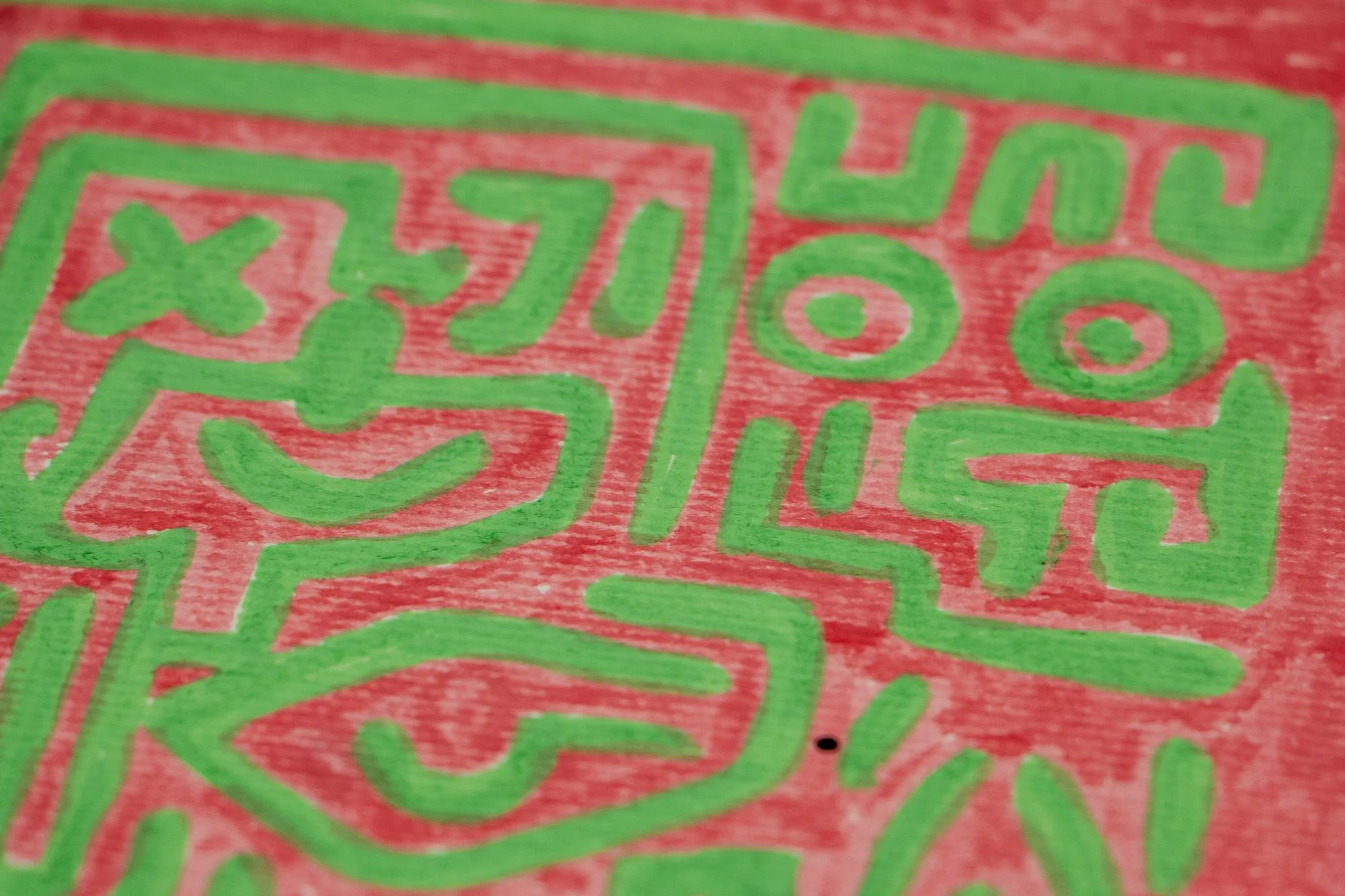 Unseen Signifiers 001 detail: close-up of the pink background with green symbolic forms, showing the border where the blue facial field curves into the surrounding sign system.