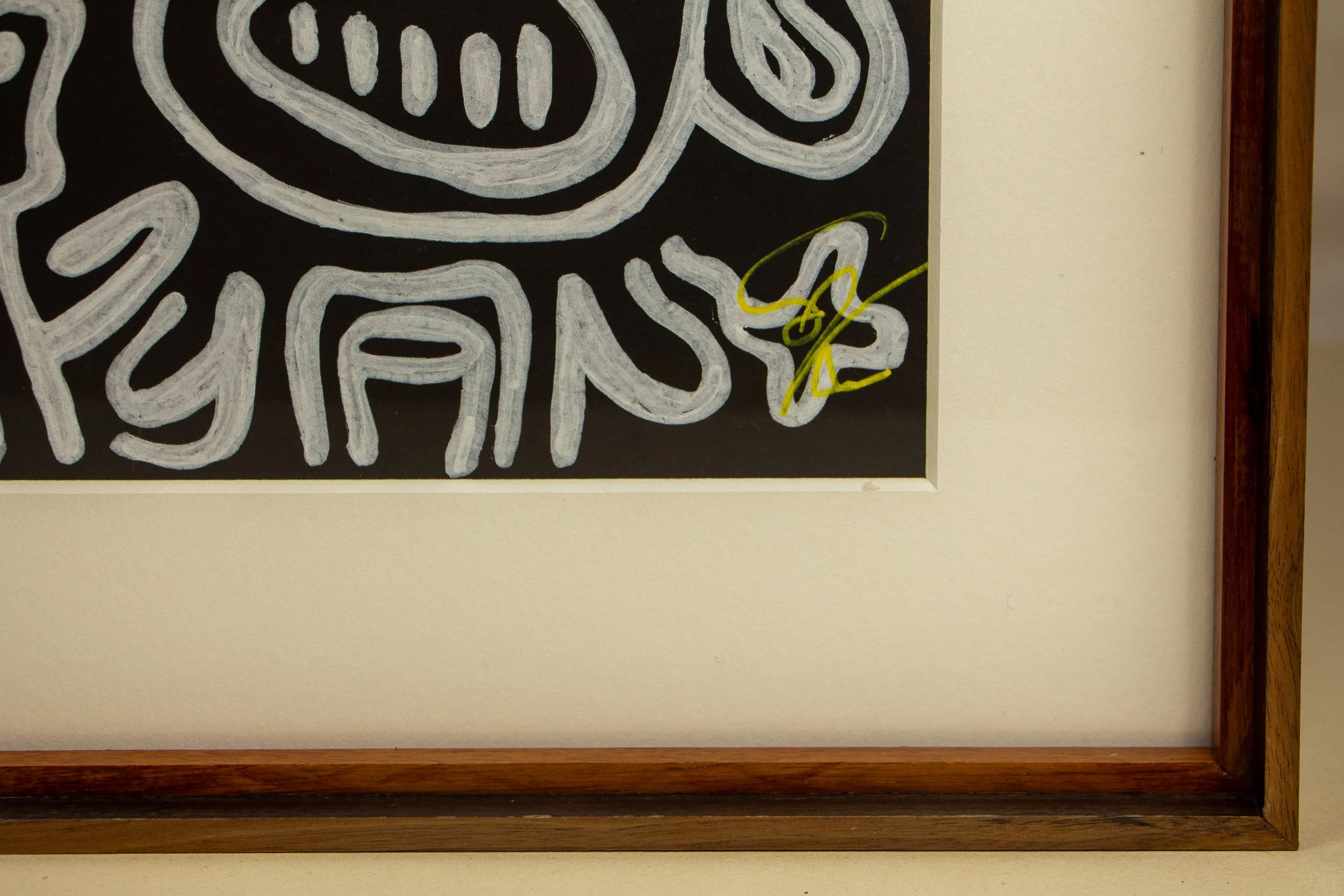 Mêlée of Discovery 001 frame: lower-right corner detail of the framed work, showing the yellow signature tucked into the composition and the precise meeting of inner and outer frame bands.