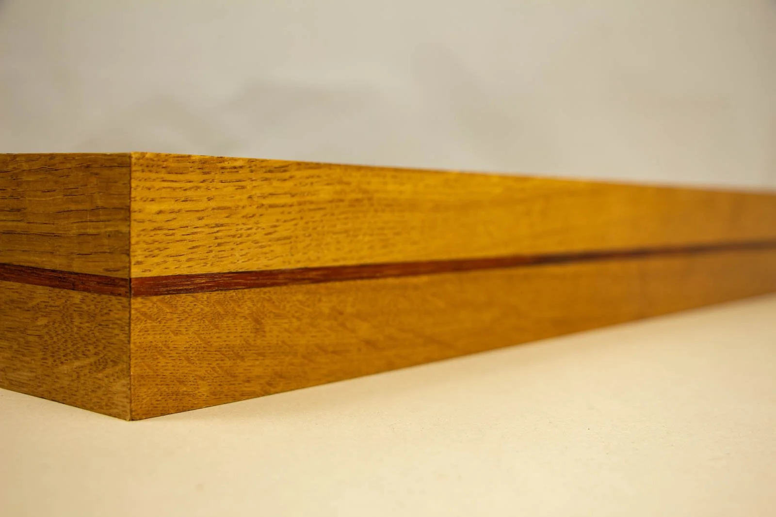 Golden Nostalgia 004 frame: trailing perspective, continuous mahogany inlay wrapping the perimeter