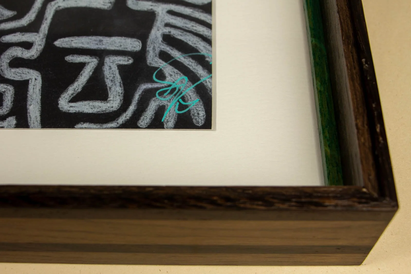 Synaptic Mythos 004 frame: lower-right interior, off-white window mat and bevel; green liner visible below the cap; signature margin shown