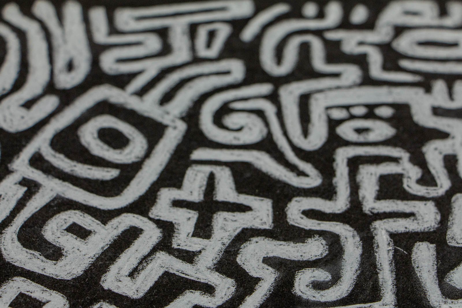 Synaptic Mythos 001 detail: zig-zag “crown” zone with seed/eye motifs and cross-forms; layered overlaps create darker seams; motion reads left-to-right