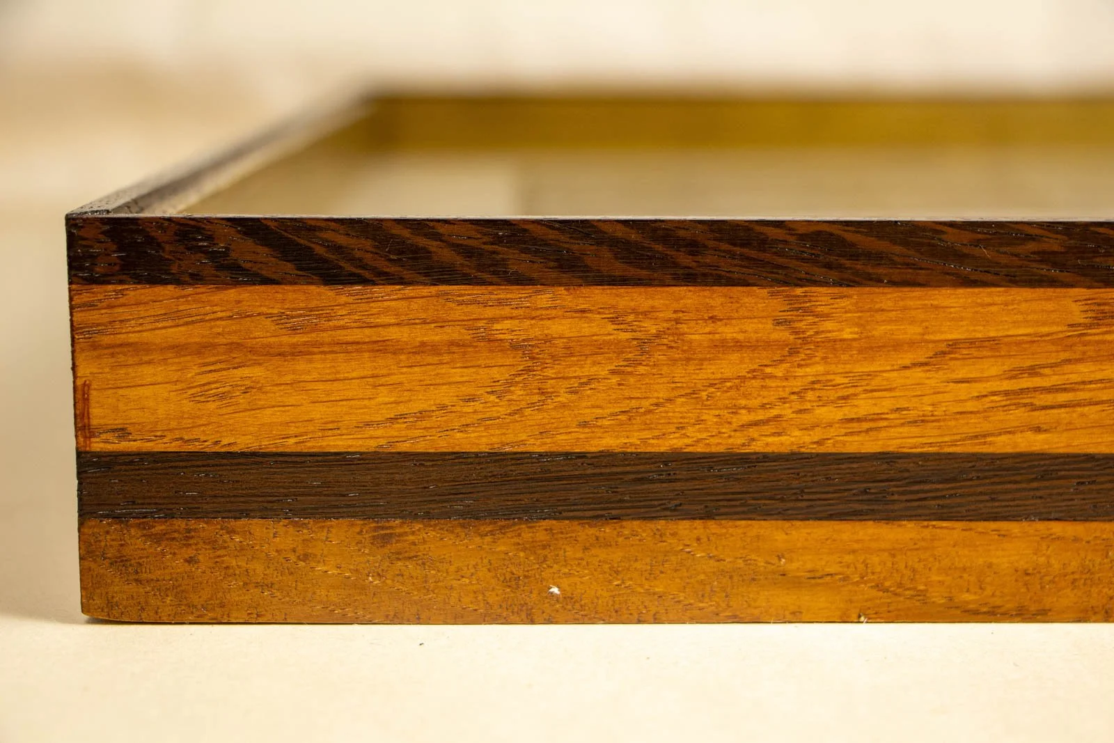 Metamorphic Entwining 003 frame: oak frame with slim wengé cap and a continuous wengé band; orange-gold grain; glazing set flush