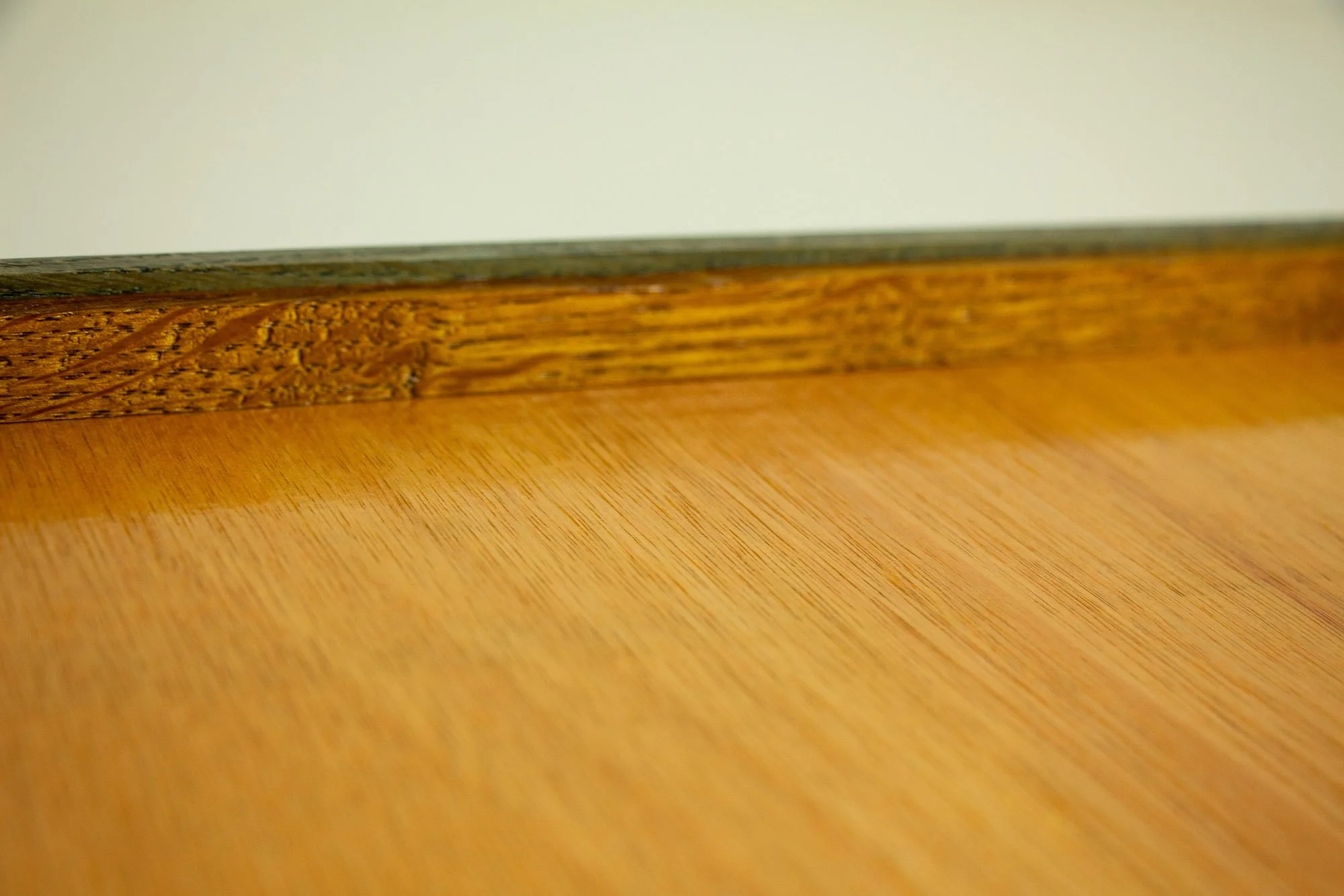 Eclipsing Gravitas 002 frame verso: low back-edge detail of the frame, showing the warm meranti plywood back panel, the inner backing rim, and the layered oak-and-mahogany construction along the reverse side