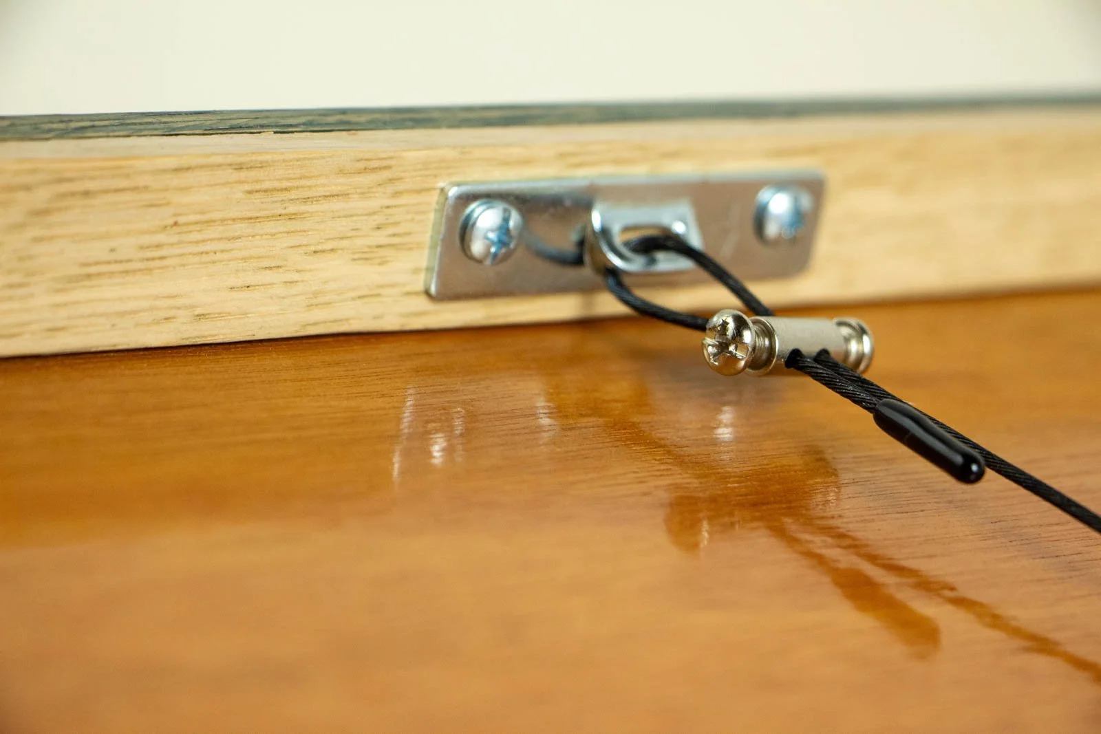 Silence’s Caesura 002 frame: rear hardware, zinc-plated mounting plate with black-coated steel cable and mini barrel clamp; natural oak inner rail with a clear varnish