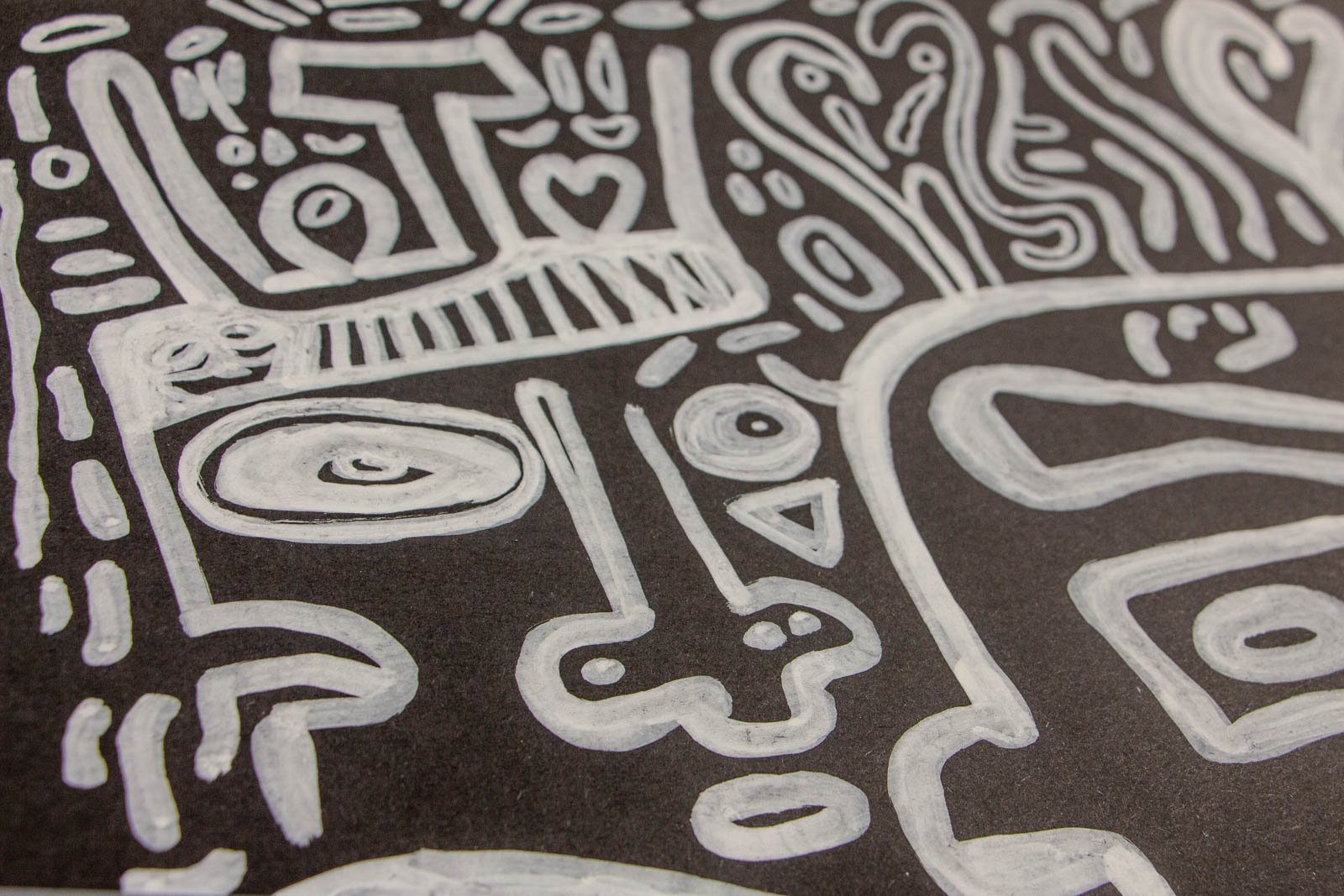 Metamorphic Entwining 001 detail: streaming ribbon lines around an angular window motif and small capsules, energetic mark-making, white ink on black paper