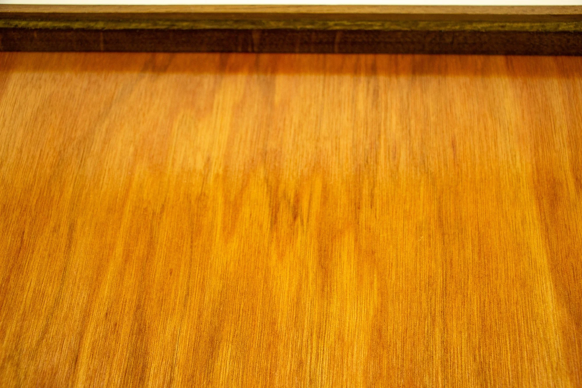 Veiled Alchemist 001 frame detail: close-up of the back panel and inner rear edge, emphasizing the fine vertical grain, warm lacquered tone, and the quiet craftsmanship of the back construction.