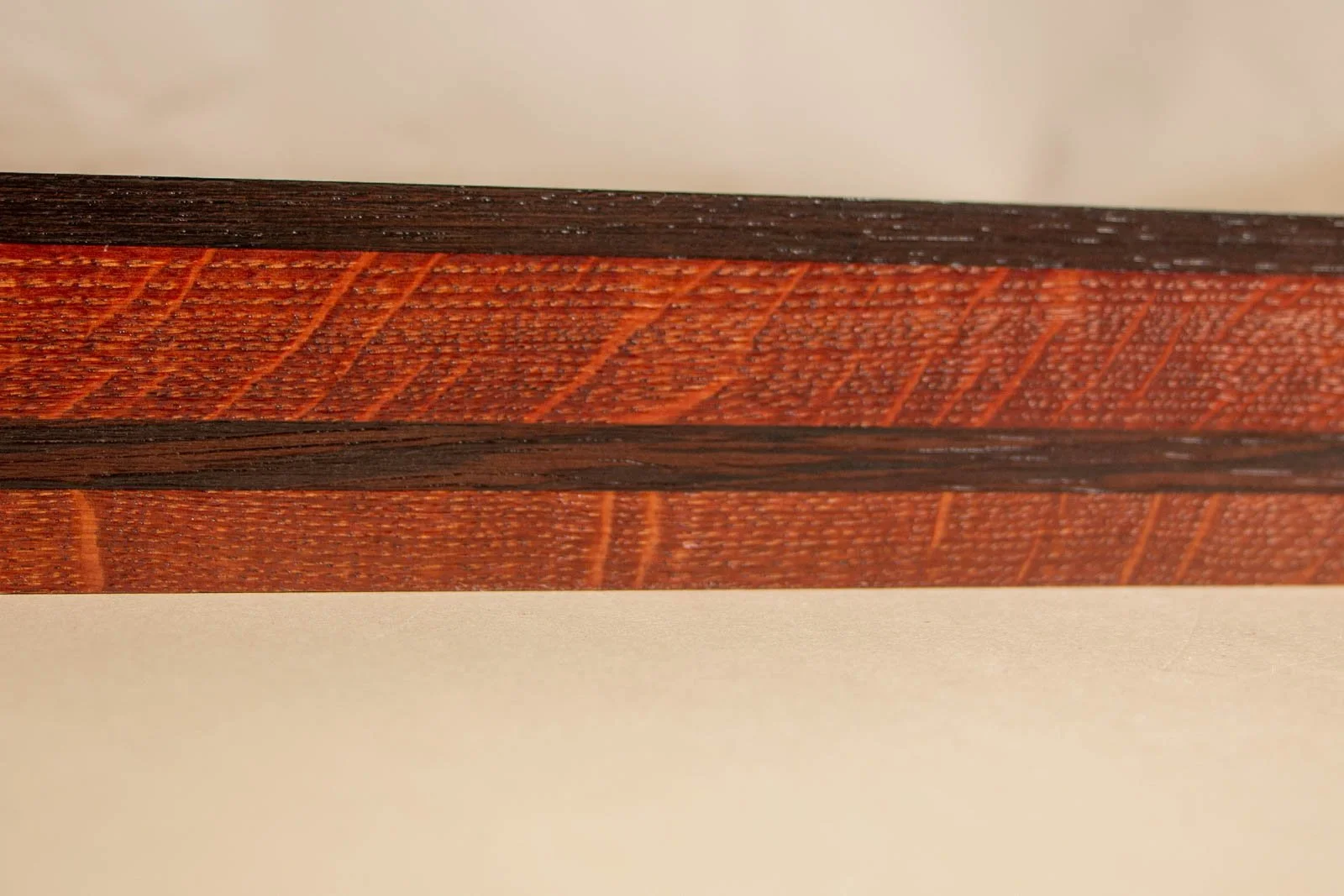 Formless Equation 004 frame: horizontal oak grain with dark wengé inlay band, fine open pores clearly visible