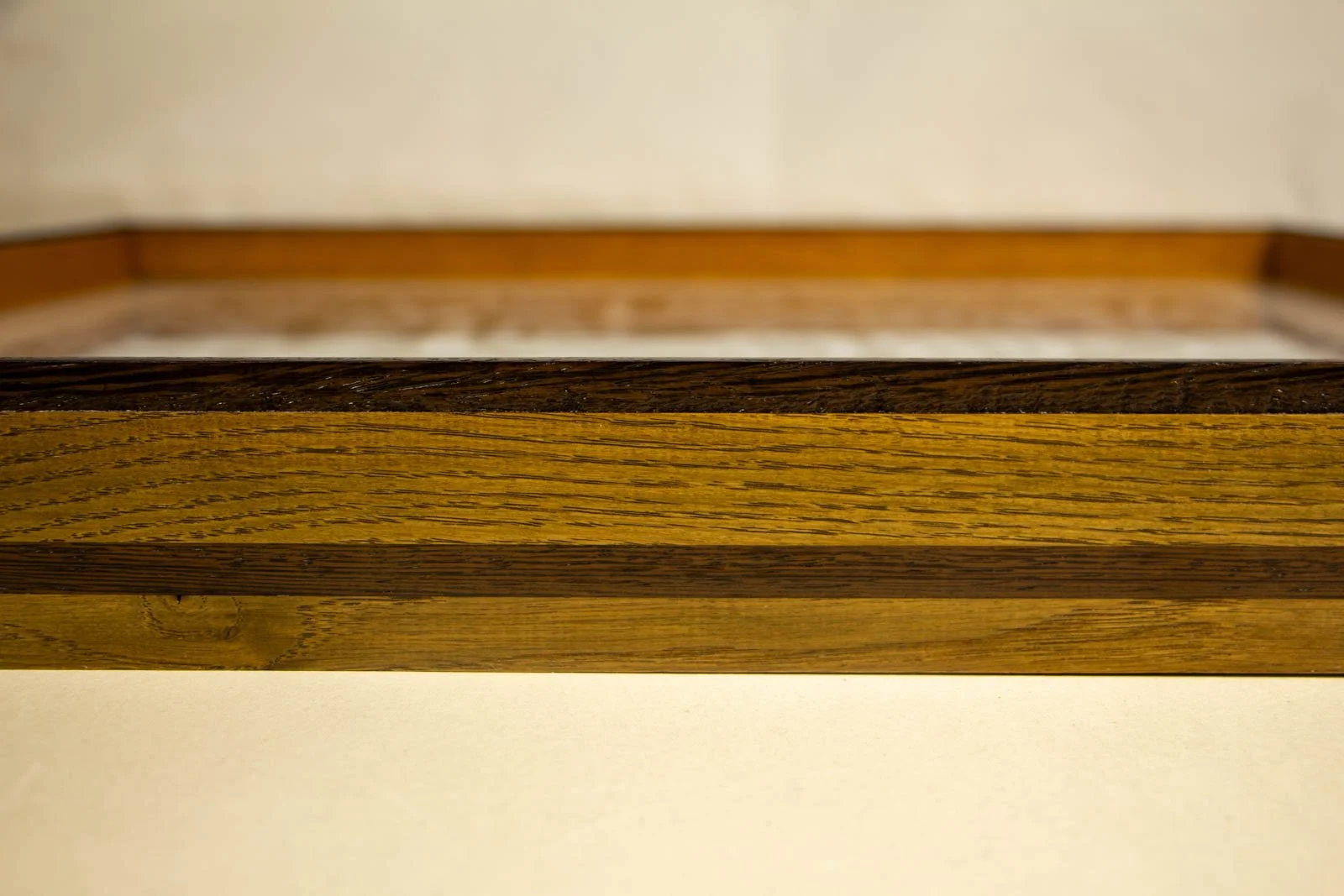 Metamorphic Entwining 004 frame: oak frame with slim wengé cap and a continuous wengé band; olive-honey grain; glass set flush