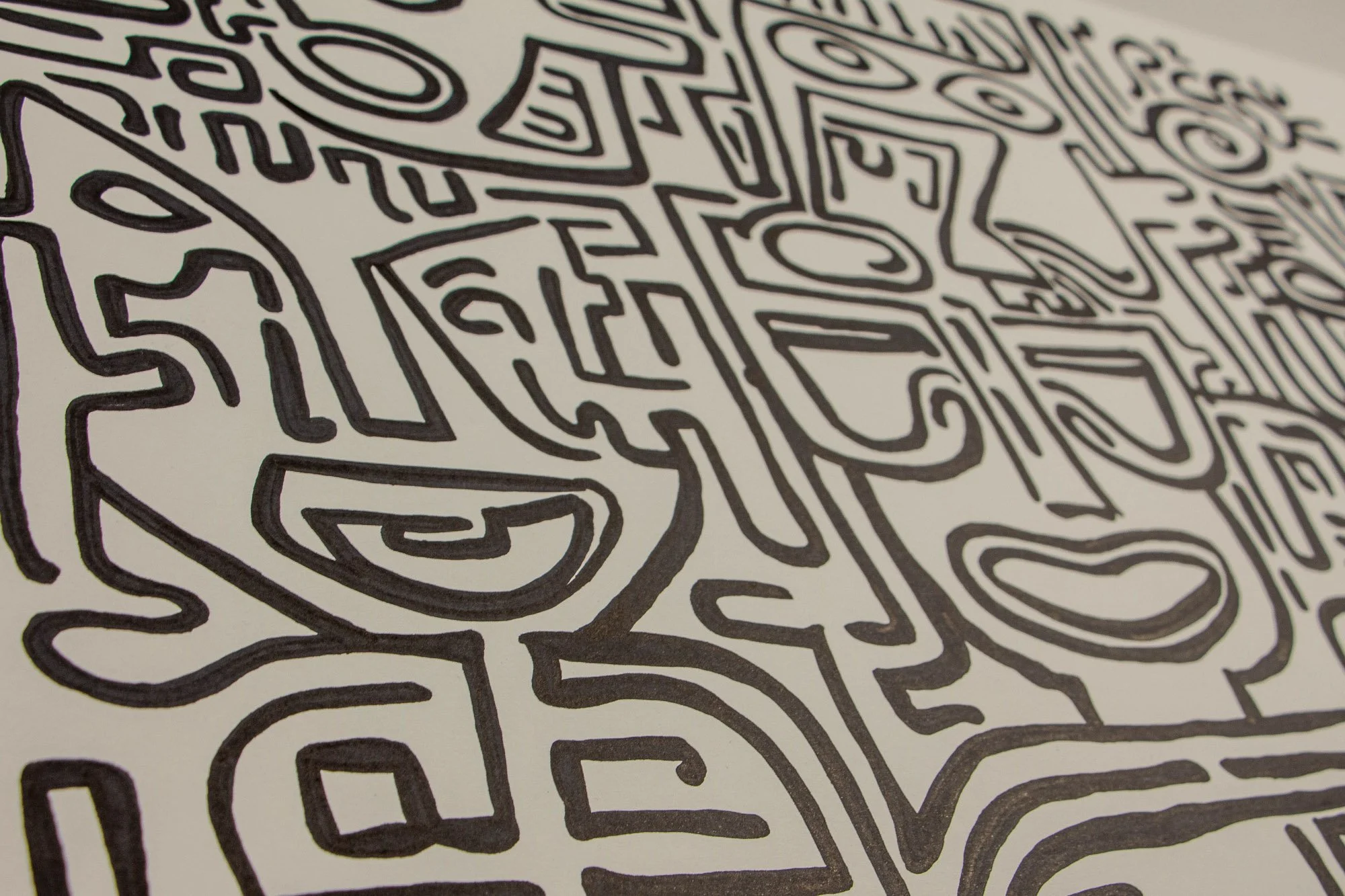 Resonant Syntax 001 detail: low angled overview of interwoven faces, pathways, and curved symbols; bold black ink lines moving across the paper surface