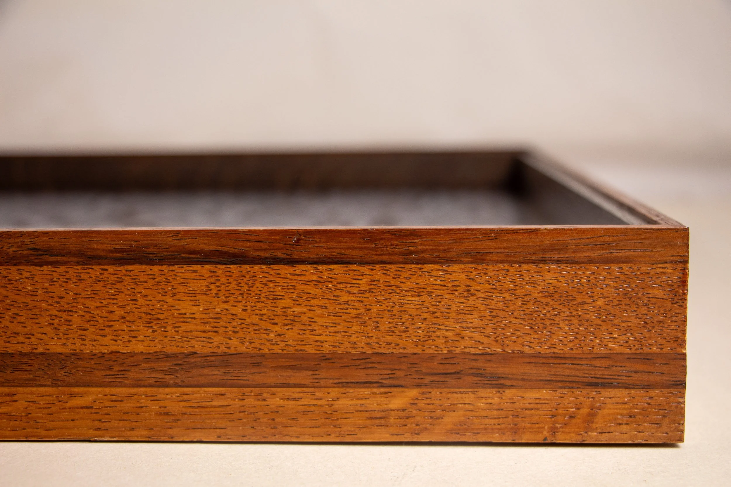 Turbulent Aegis 003 frame detail: frontal side close-up of the frame edge, revealing the wide warm-toned wood band, darker horizontal inlay, and the structured geometry of the handcrafted profile.