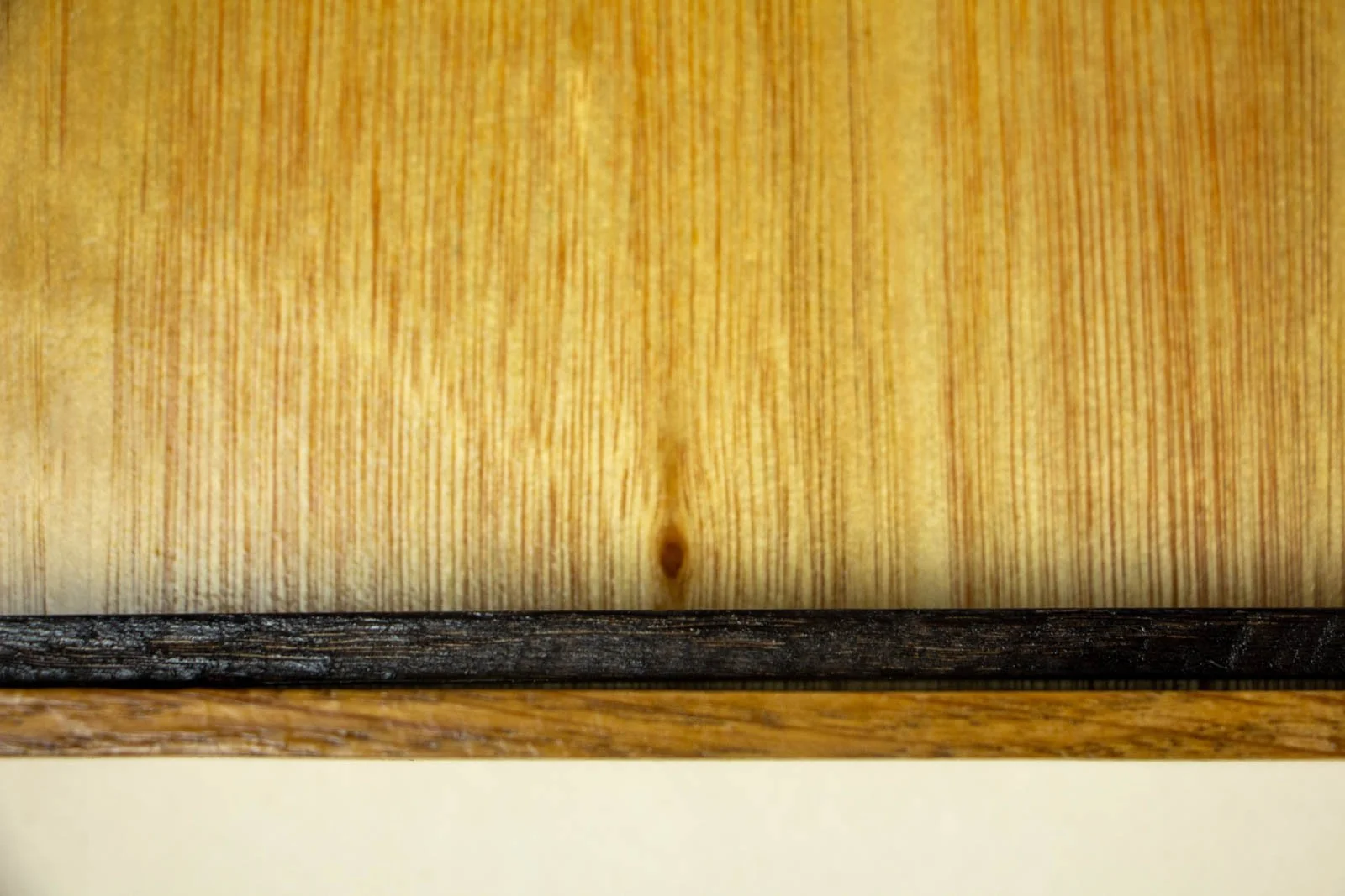 Golden Nostalgia 001 frame: back edge, warm honey-toned hardwood backboard; dark inner spacer along the rabbet; layered construction visible