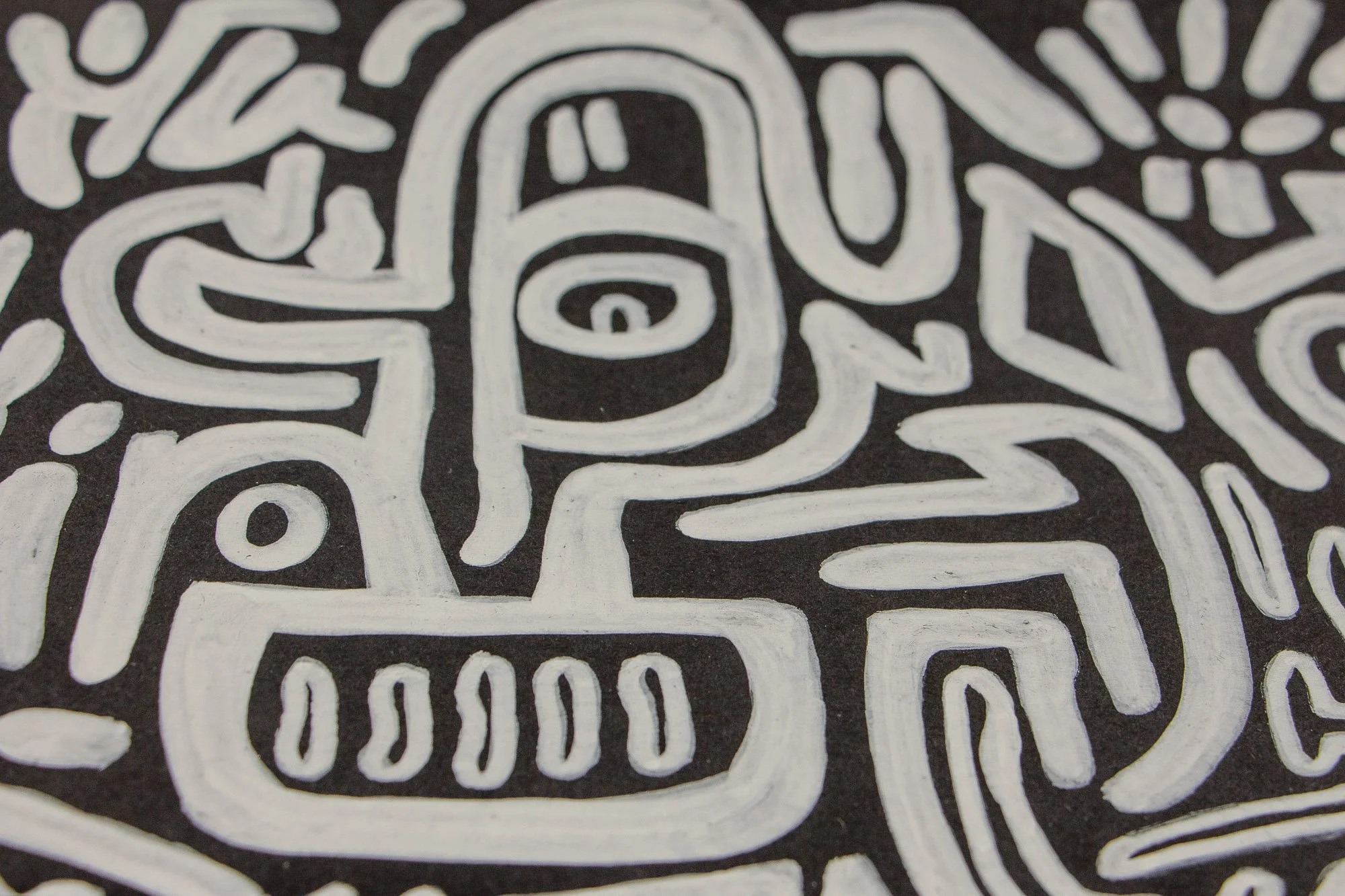 Turbulent Aegis 002 artwork detail: close-up of a figure with a single eye set inside an elongated head-like form, surrounded by branching lines, triangular accents, and a sun-like motif.