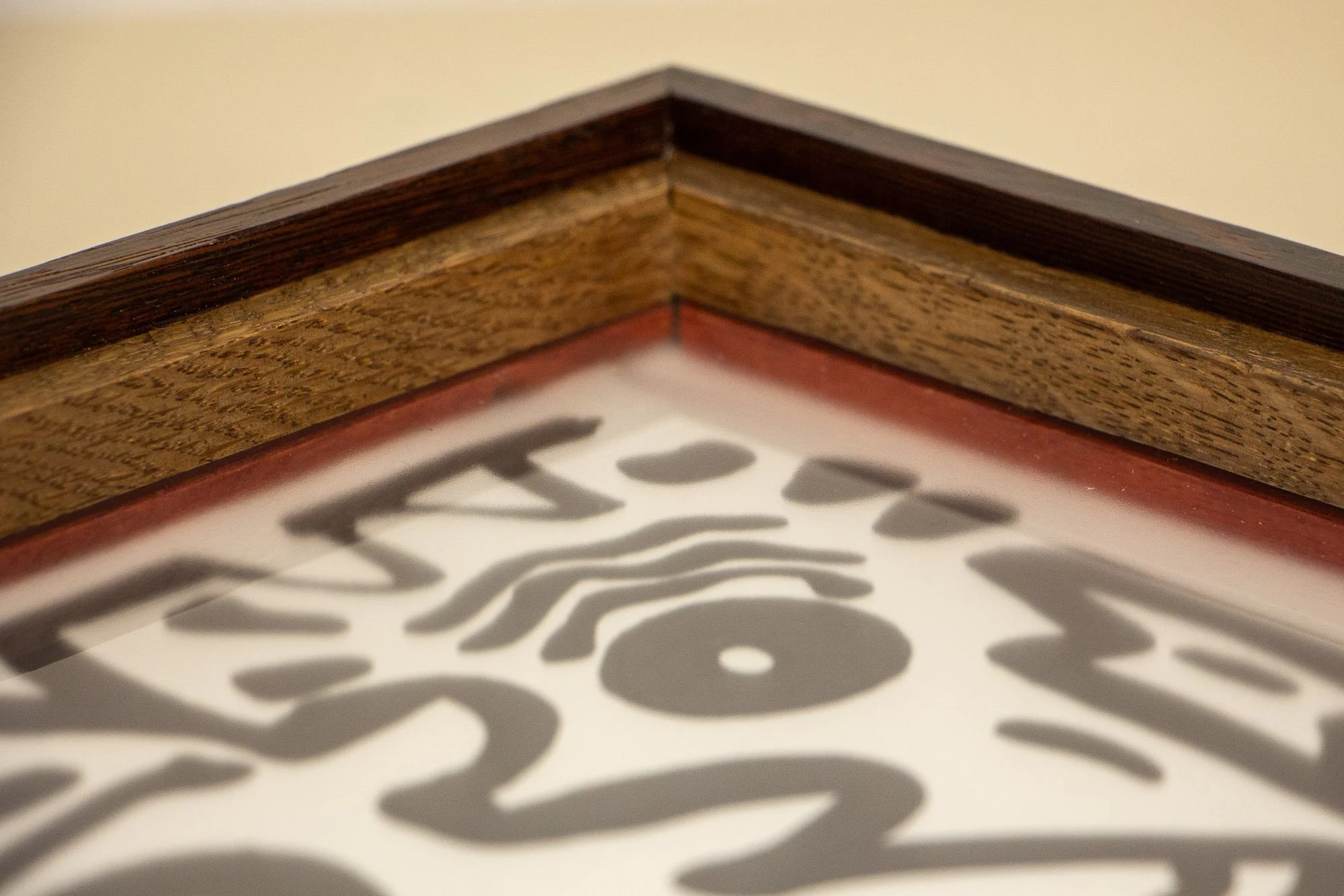 Elusive Cocoon 001 frame: inner corner with palisander outer rail, light ash-toned band, and red inner liner beneath the glazing.