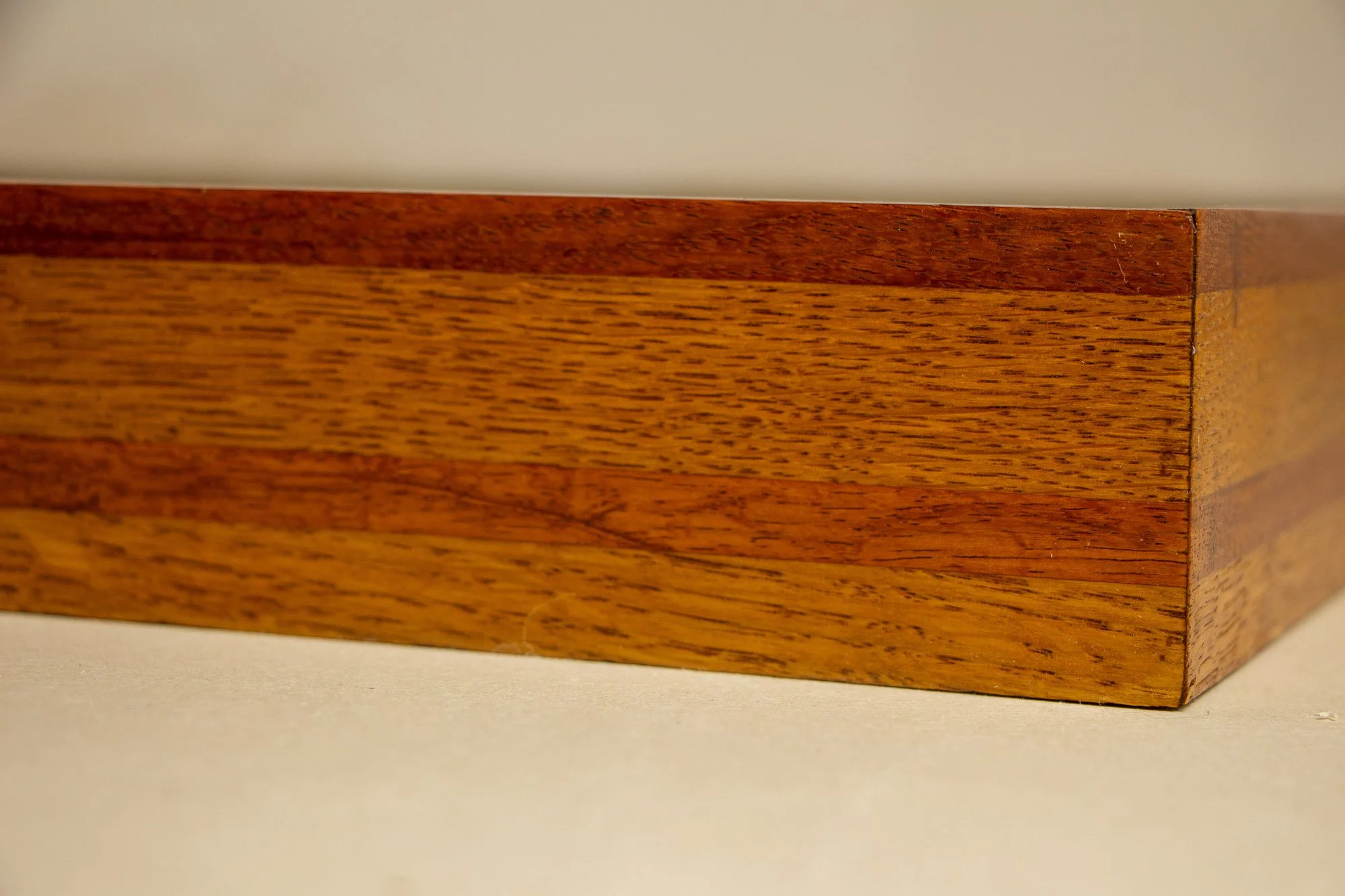 Unseen Signifiers 006 frame detail: corner close-up of the frame profile, showing the crisp miter join and the layered striped wood construction wrapping around the edge. mahogany, oak and beech wood.