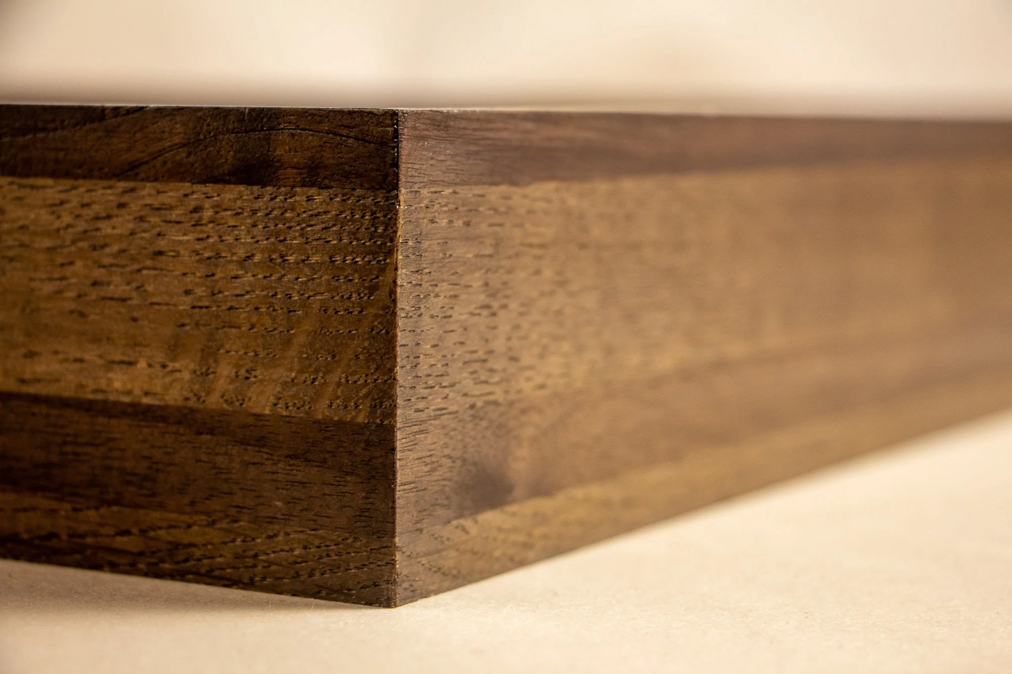 Luminous Parallax 004 frame: corner side view of the frame, highlighting the clean mitred join, horizontal wood banding, and the restrained dark-toned finish that echoes the artwork’s shifting contrasts.