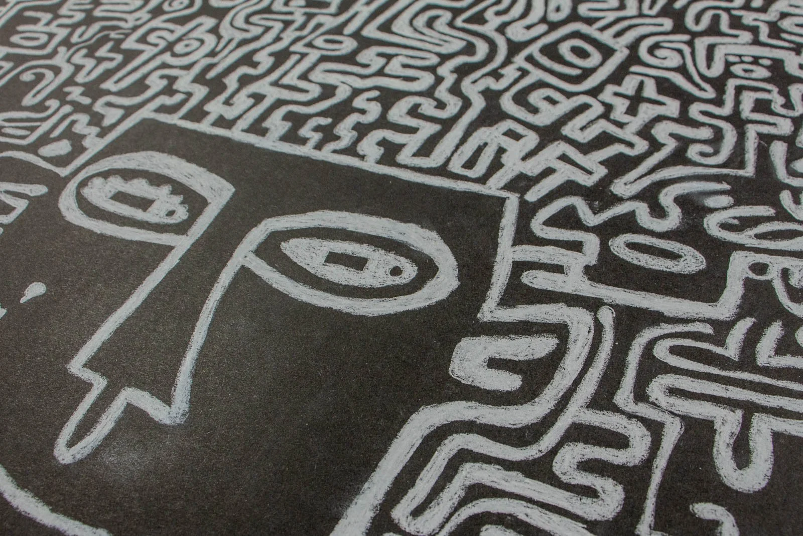 Synaptic Mythos 001 detail: oblique view of the face boundary below a compact maze, long triangular nose and almond eyes; strokes sit chalky on matte black; faint halos where lines double back