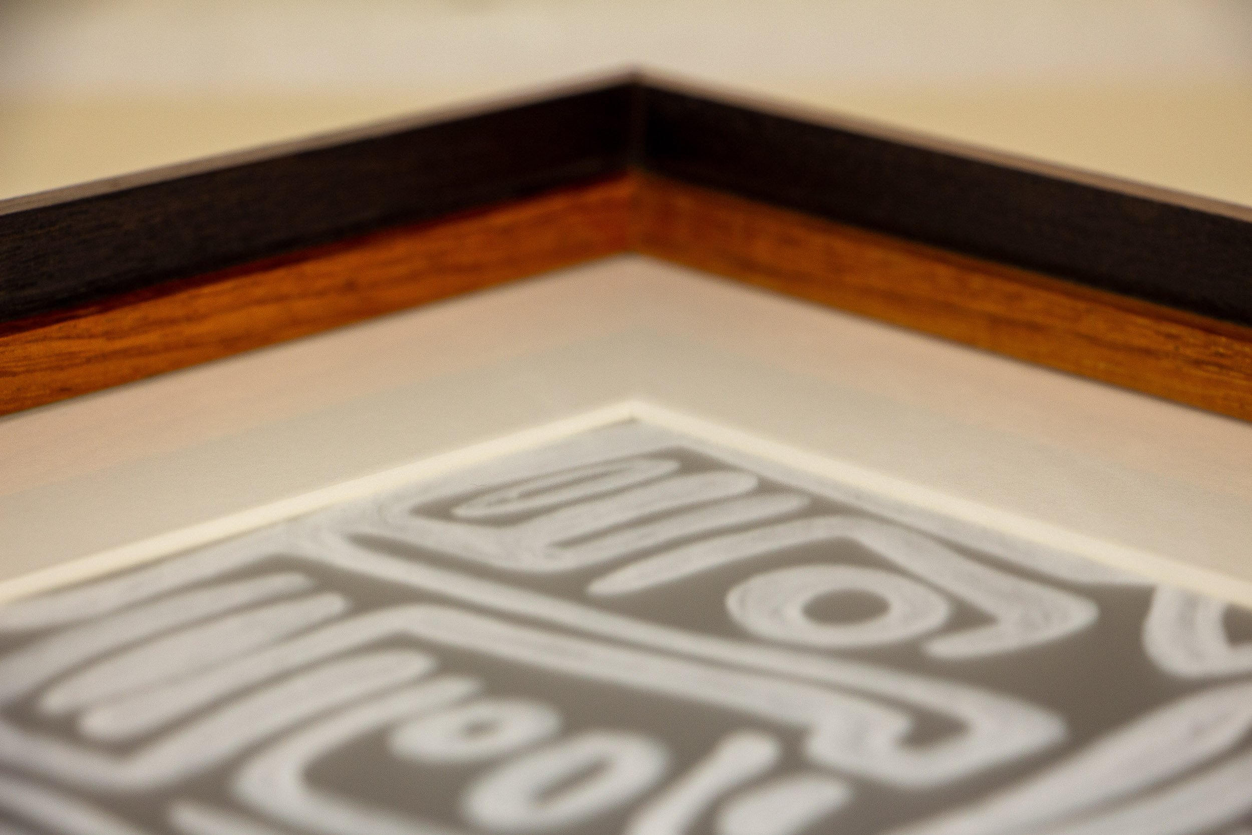 Mêlée of Discovery 005 frame detail: frontal view of the frame edge, showing the textured pale band with pronounced hand-worked markings between darker wood layers.