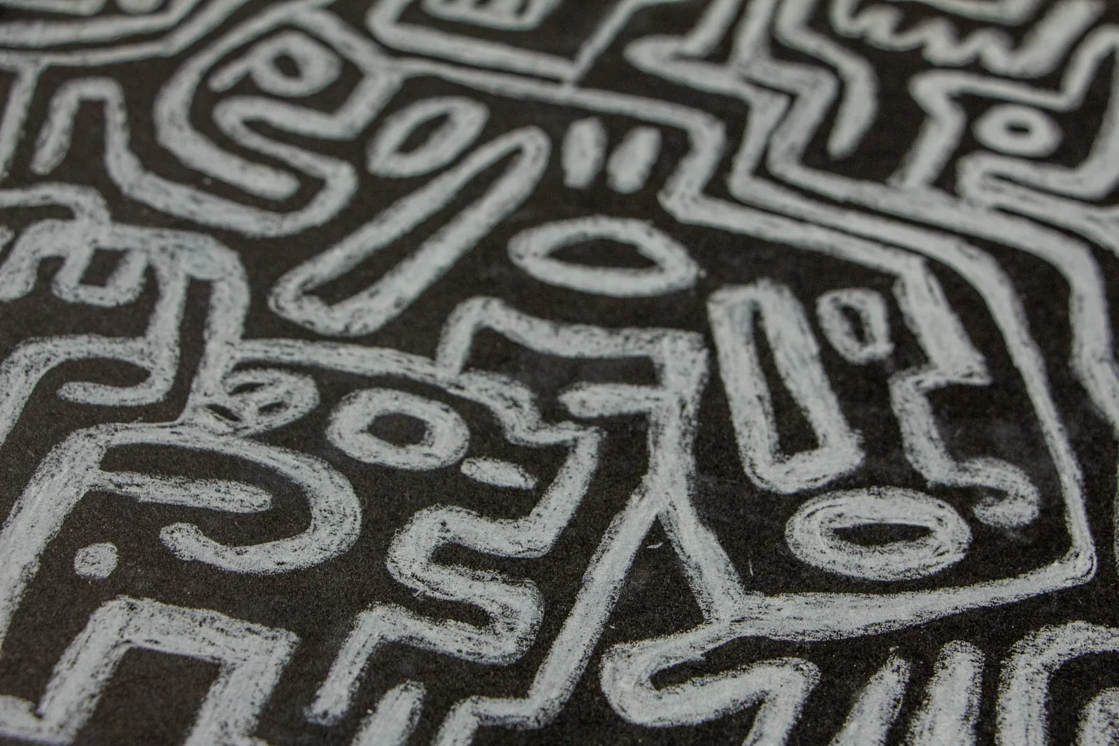 Synaptic Mythos 003 detail: angled view across a field of faces and seed-ovals; overlapping strokes leave darker seams where they meet