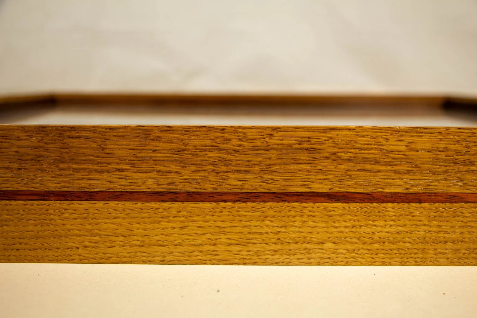 Golden Nostalgia 001 frame: long side elevation, calm, even oak grain; the mahogany line runs straight and true