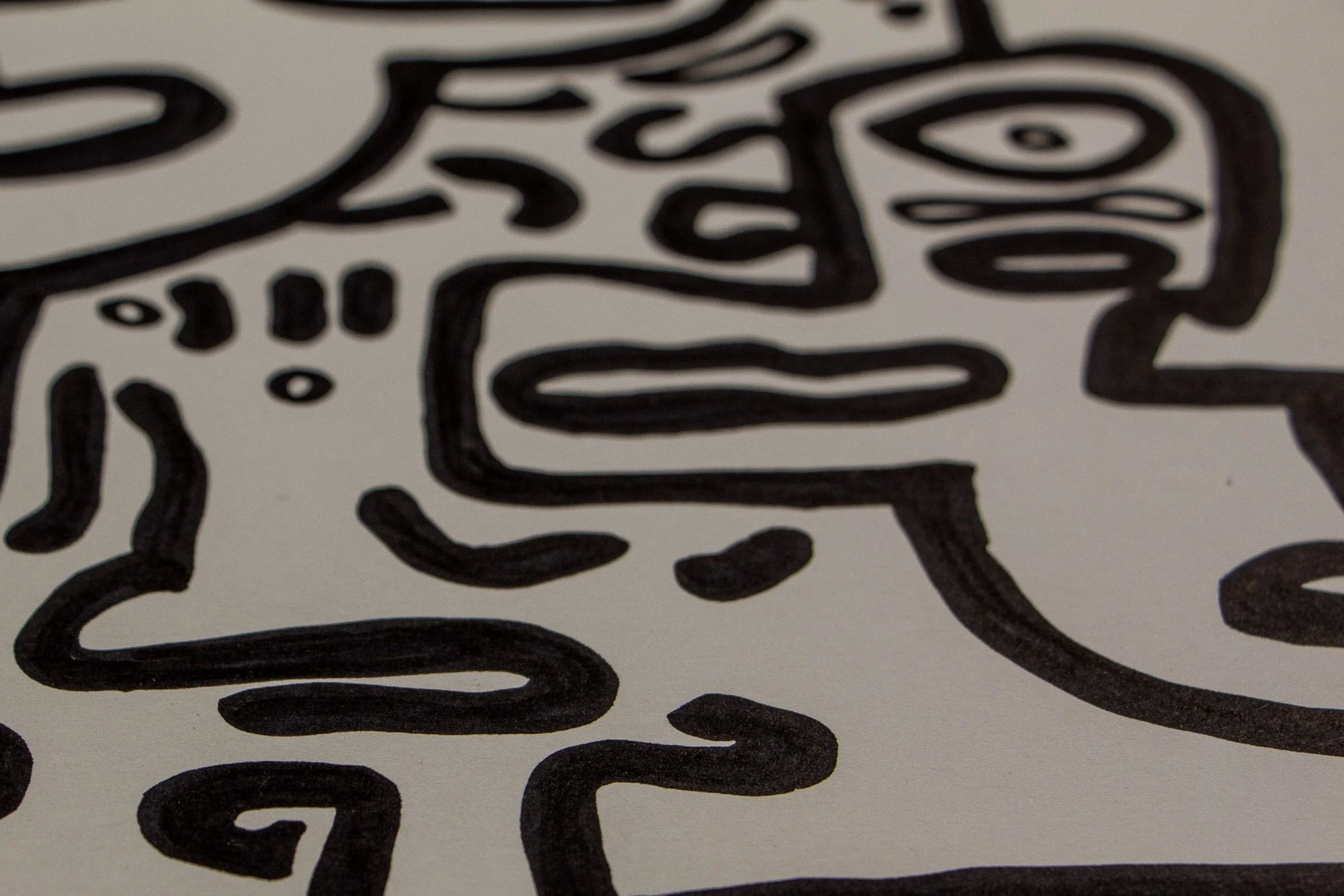 Veiled Alchemist 003 detail: soft-focus close-up of a simplified face fragment with one eye and a horizontal mouth, emphasizing the drawn line quality, surface texture, and quiet spatial depth of the work.