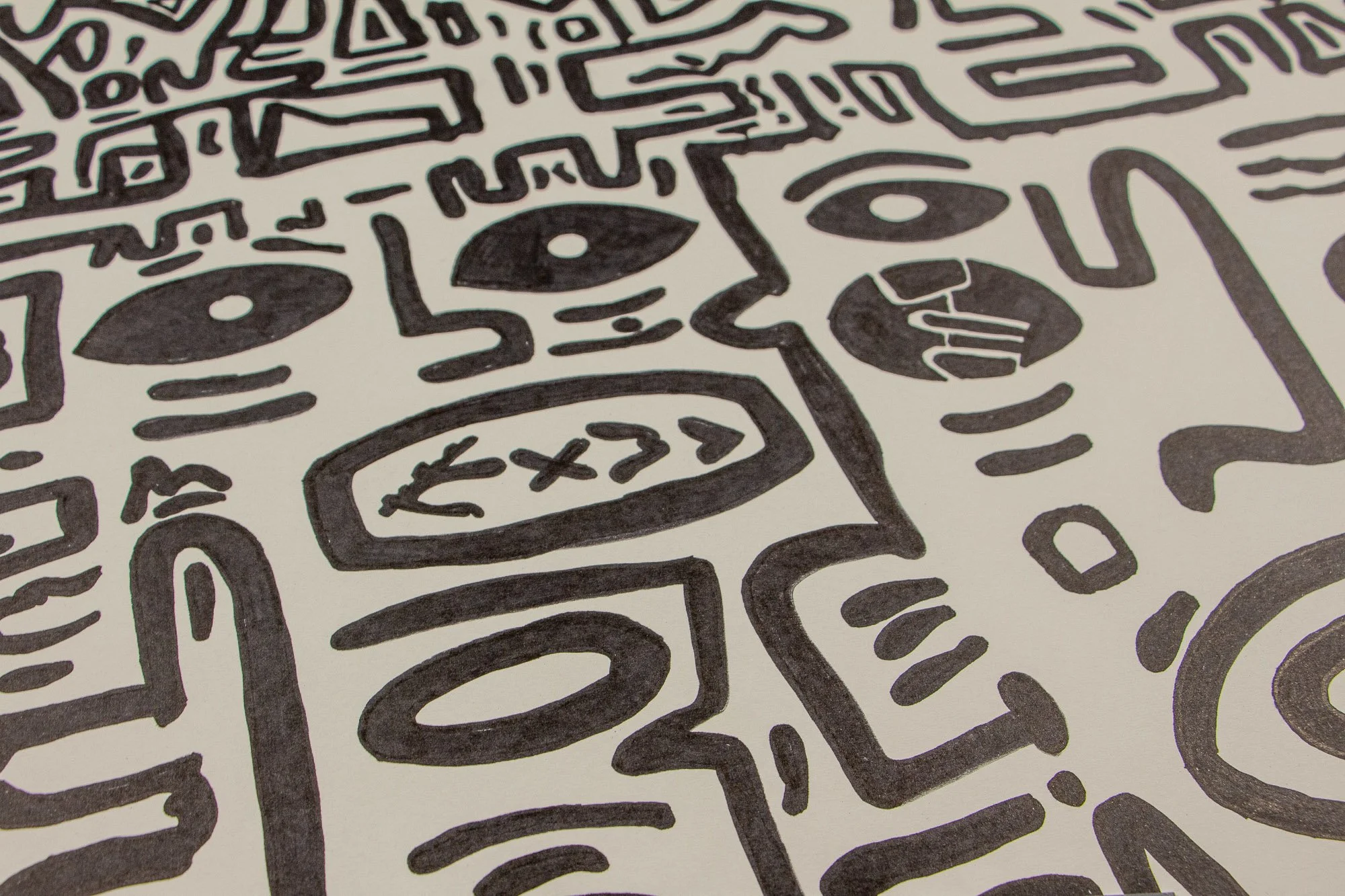 Elusive Cocoon 001 detail: angled close-up of a vertical mask-like form with an elongated oval mouth, surrounded by circular eye motifs, compact symbols, and bold black contour lines on warm white paper.