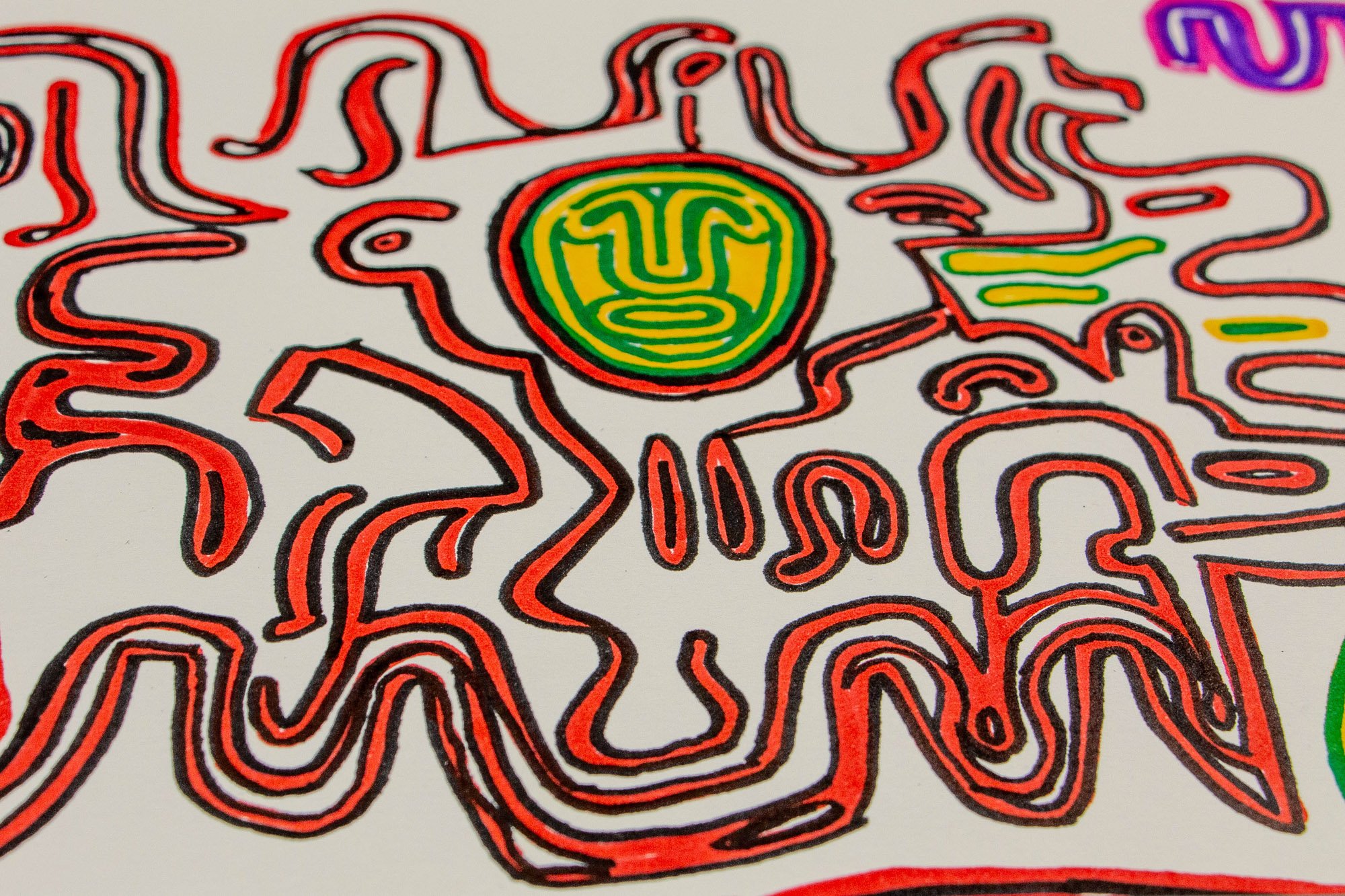 Eclipsing Gravitas 002 detail: close-up of a red biomorphic figure with a circular green-and-yellow face-like medallion at its center, surrounded by curling lines, droplet forms, and wave-like extensions on white paper.