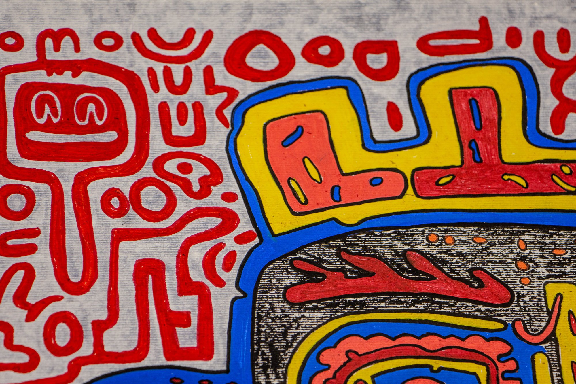 Unseen Signifiers 003 detail: upper-left corner of the composition, where a smiling red figure and surrounding symbols frame the yellow-and-red crown-like border above the face.