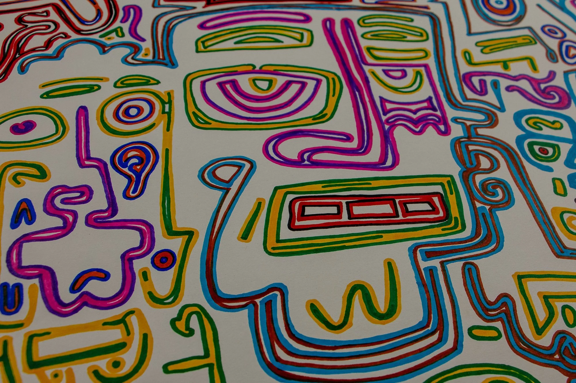 Eclipsing Gravitas 001 detail: close-up of interlocking multicolored face-like forms, with a rectangular red mouth, pink and violet contours, green and yellow accents, and flowing blue outlines on white paper.