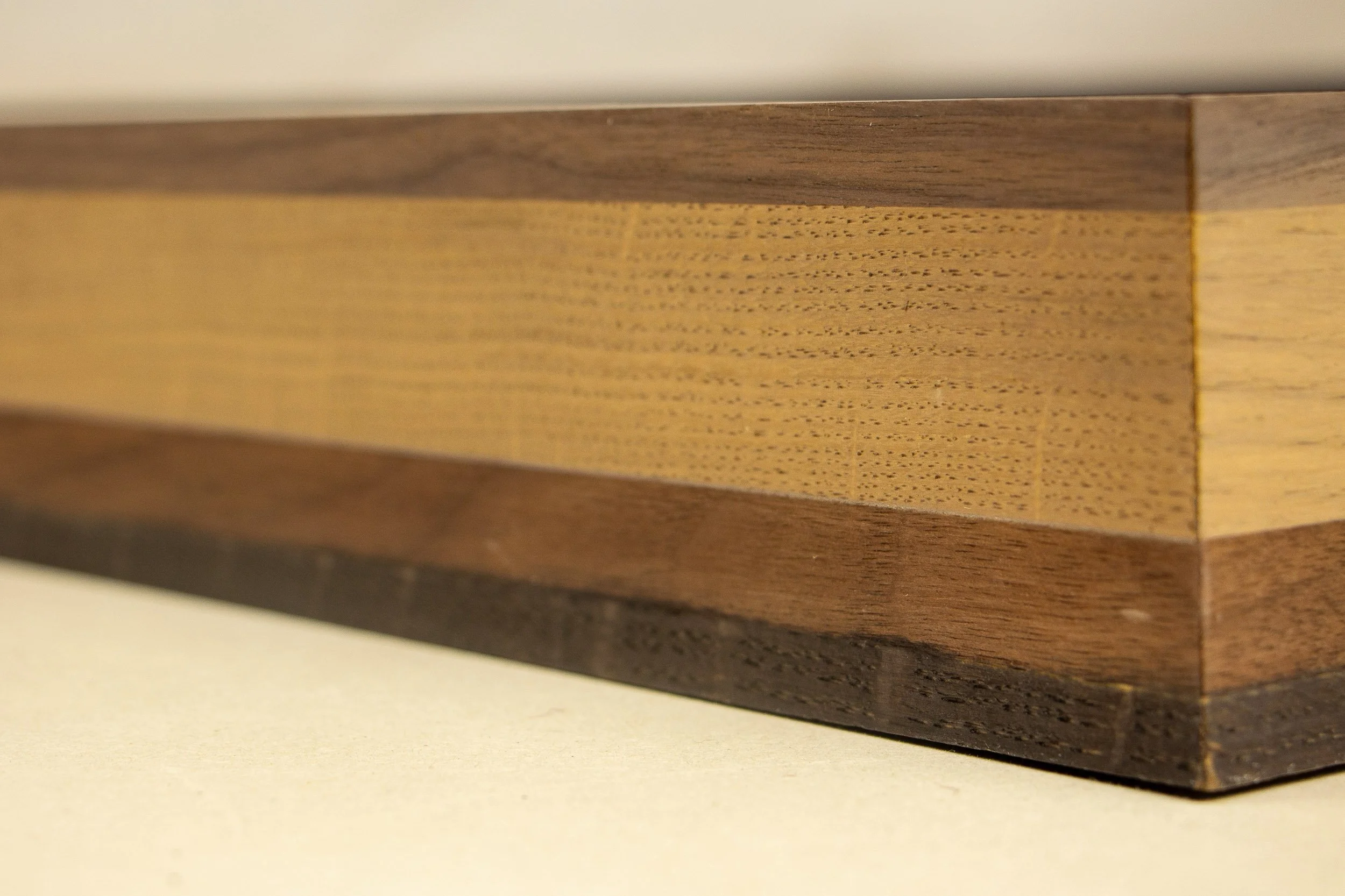 Mêlée of Discovery 003 frame: close-up of the frame profile, where subtle grain patterns move across the light central strip and darker surrounding bands.