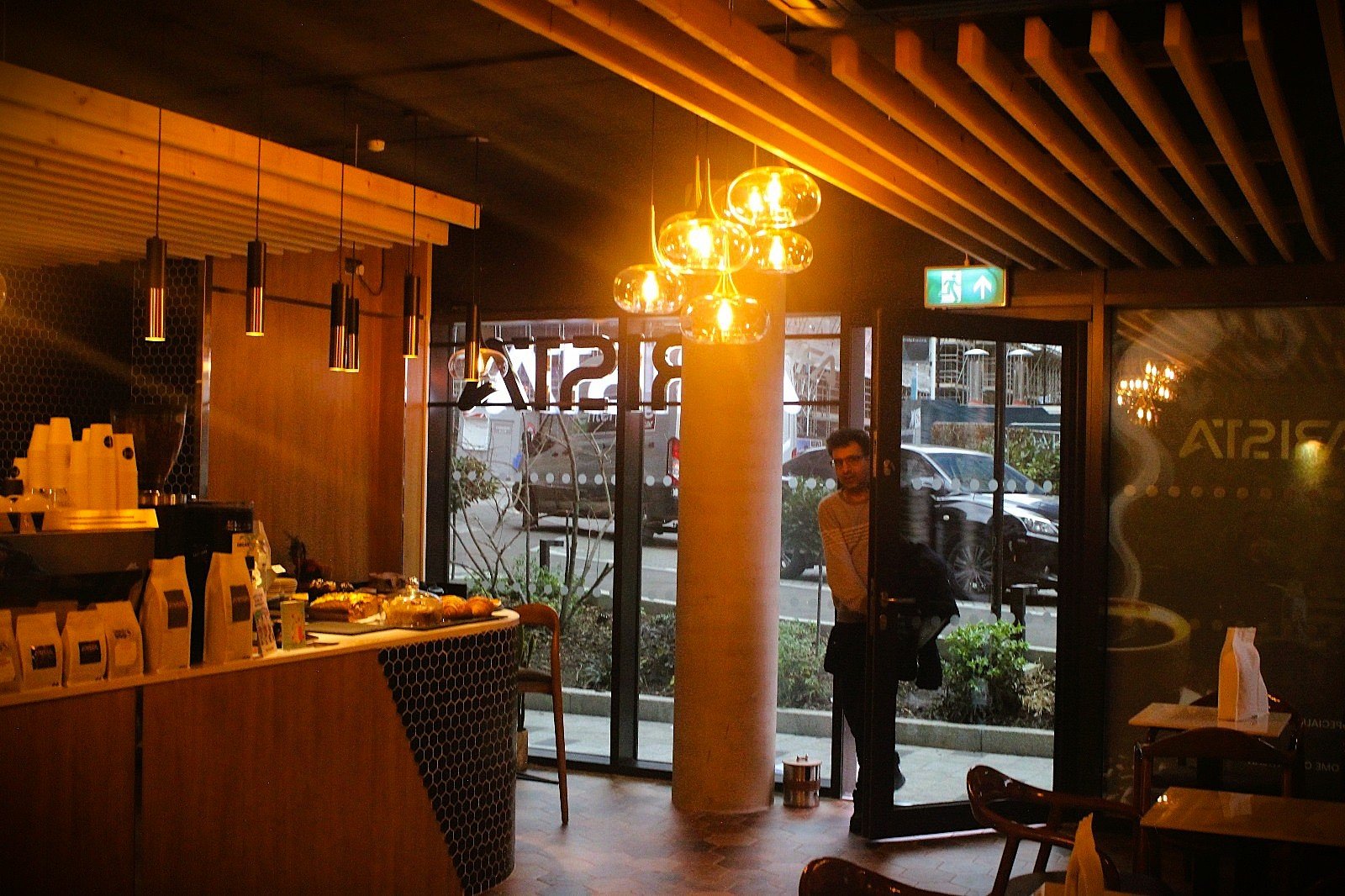Arista café interior fit-out in Brentford, London, with warm timber, bespoke seating and integrated lighting.