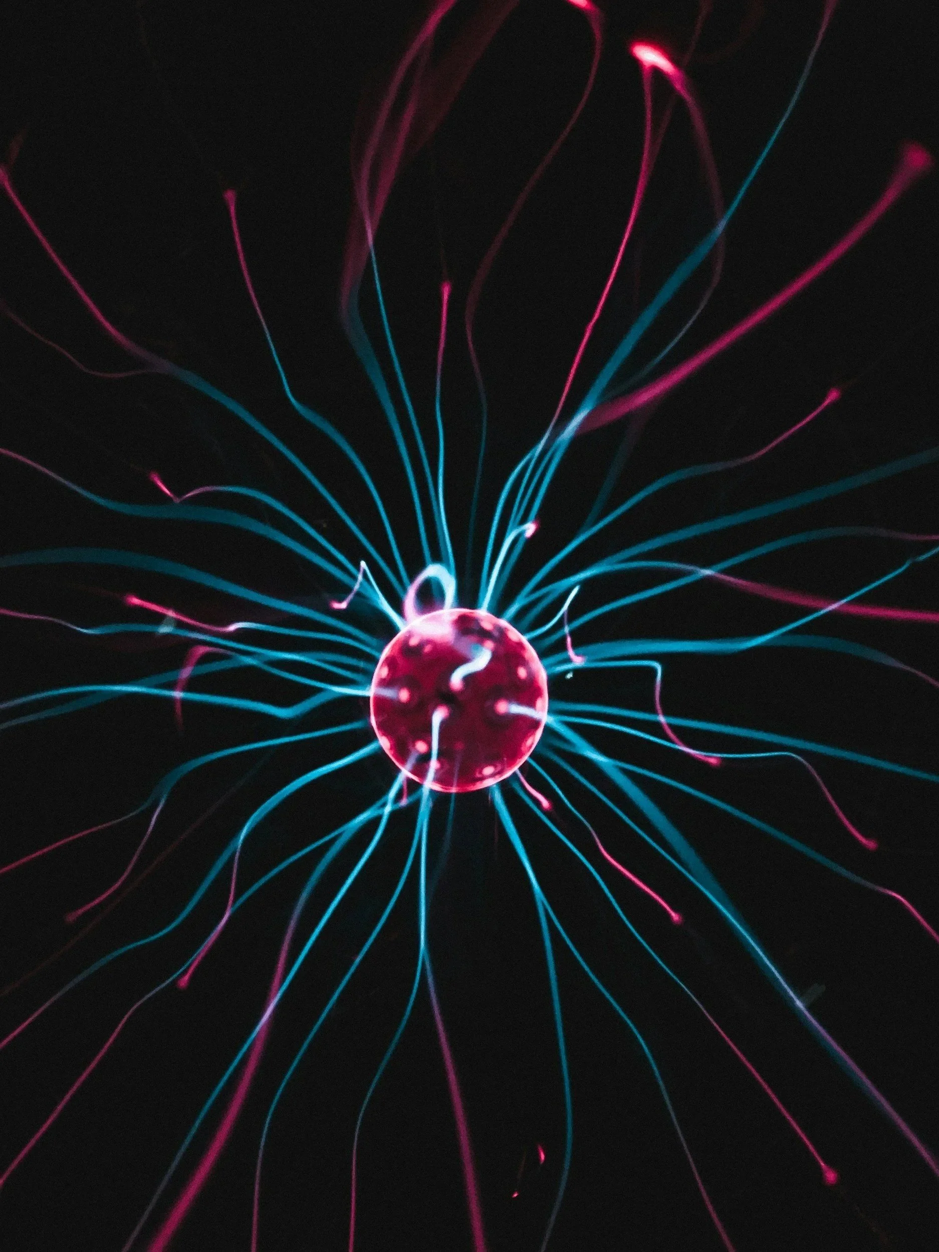 Close-up of a plasma globe with colorful electric streams emanating from the center.