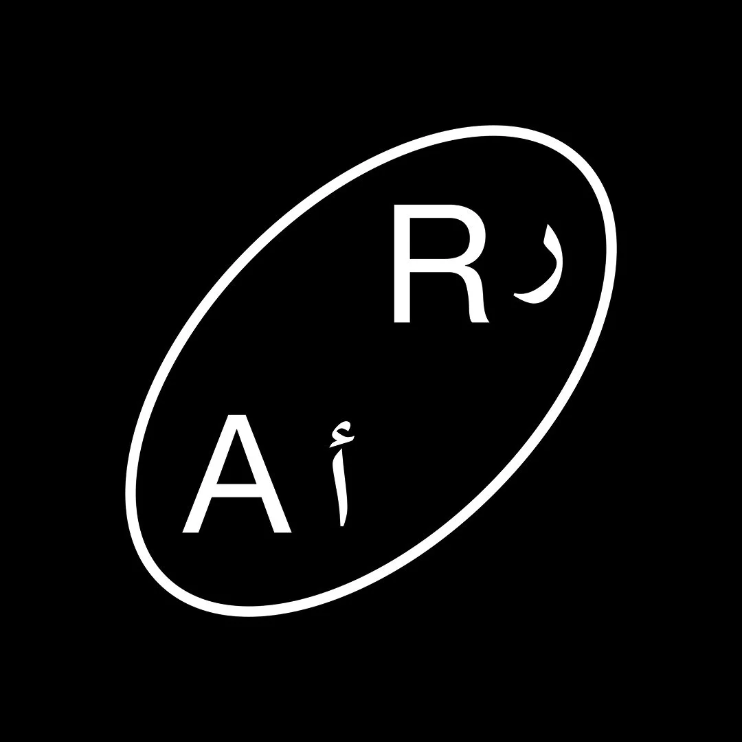 A black background with a white oval. Inside the oval, there are the white letters 'A', 'R', and a 'J' with a tilde on top. The letters are arranged randomly inside the oval.