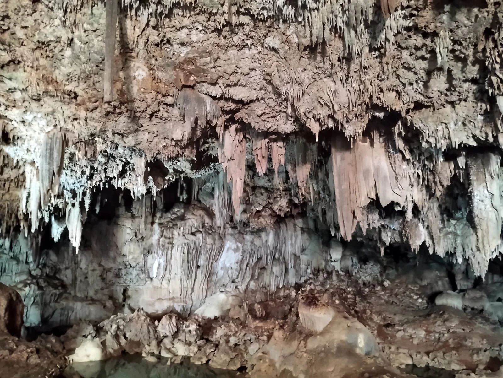 Inside a cave with stalactites hanging from the ceiling and stalagmites rising from the ground.