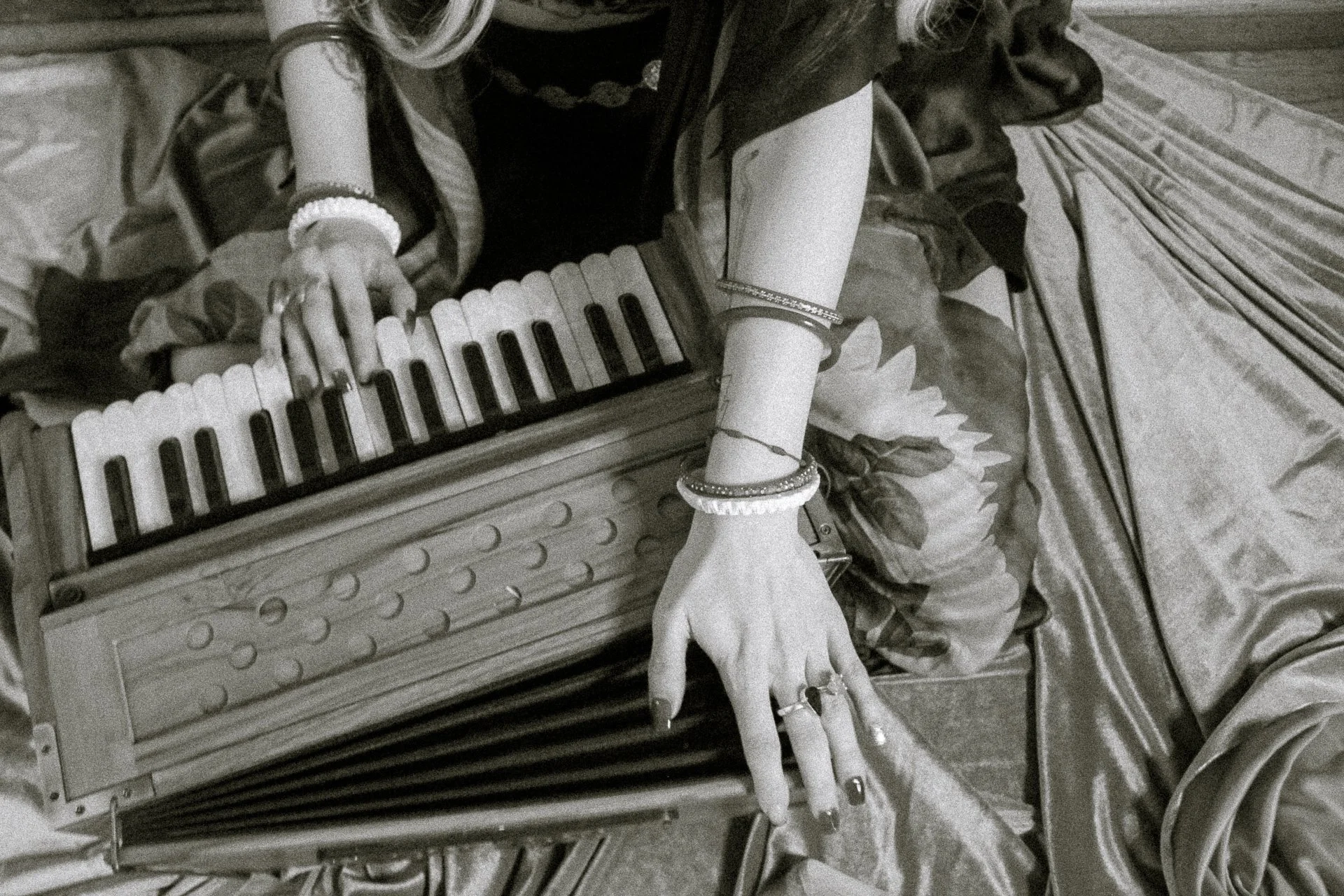 Close-up of hands playing a harmonium during devotional music practice