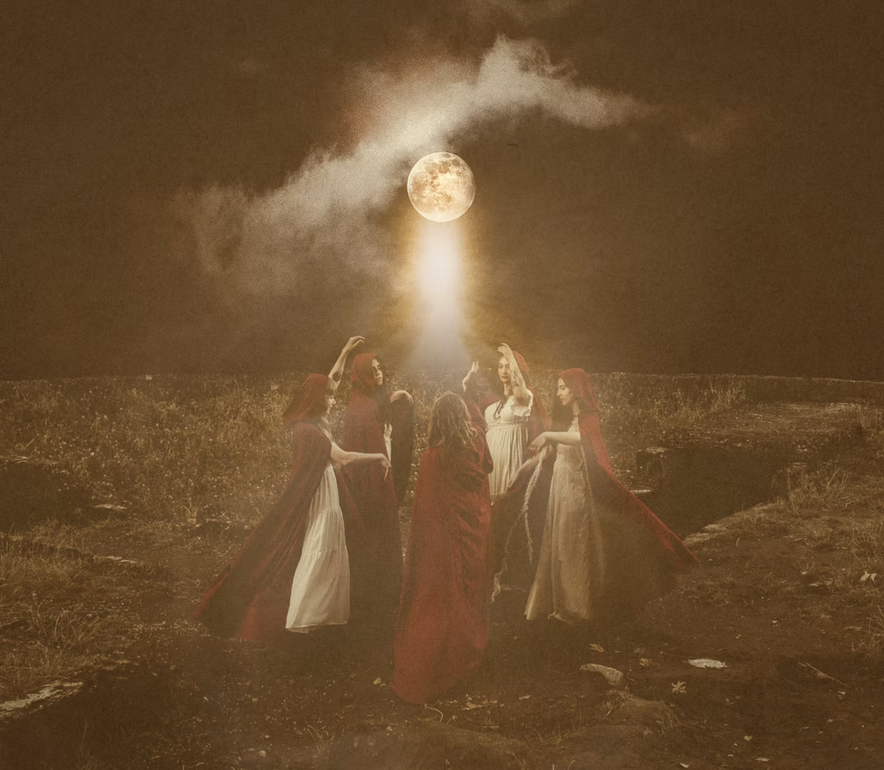 Women in flowing red cloaks gathered in a ritual circle under a full moon