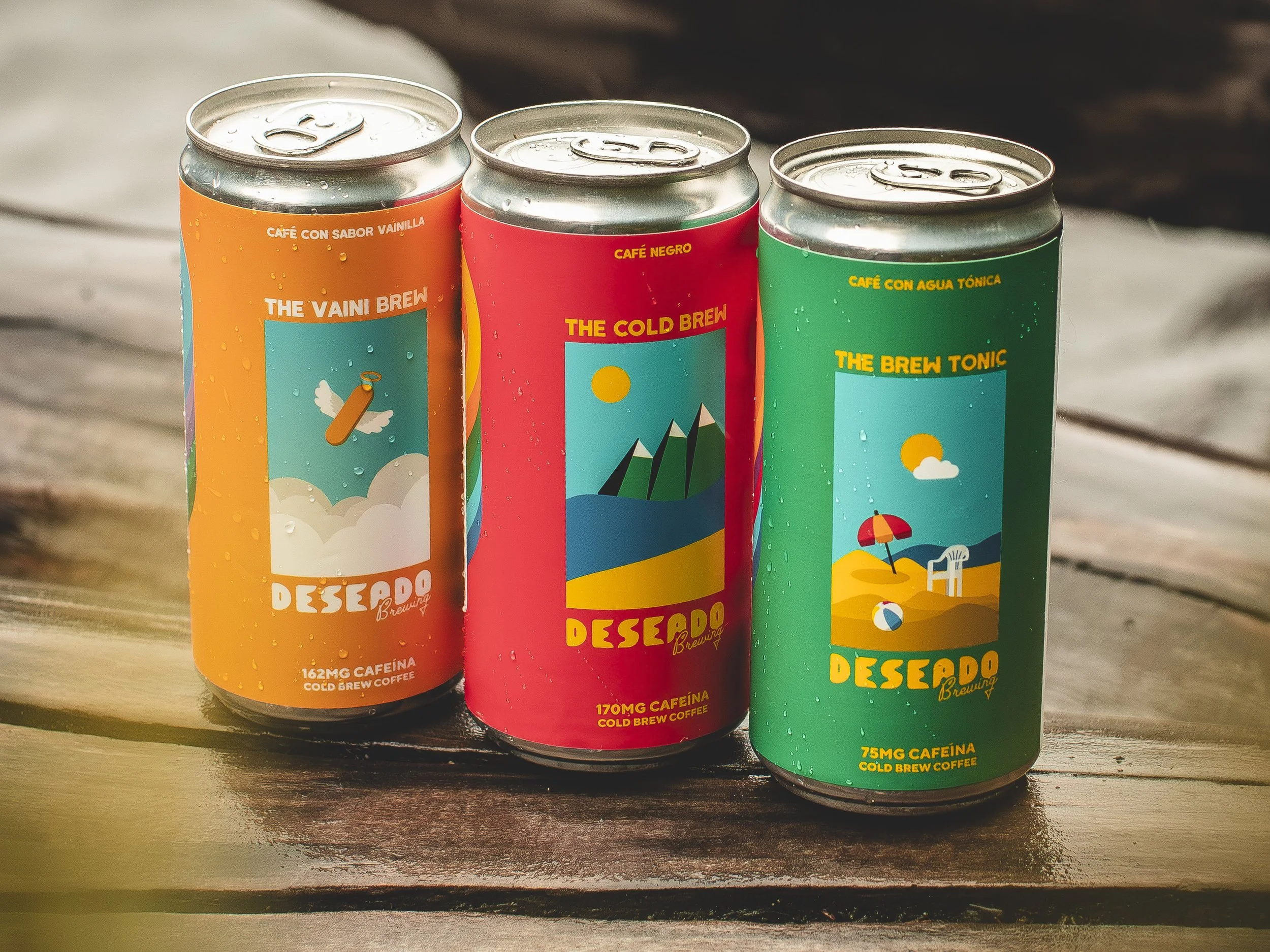 Lata de café con diferentes sabores y colores, decoradas con ilustraciones de paisajes y elementos de verano, colocadas en una mesa de madera