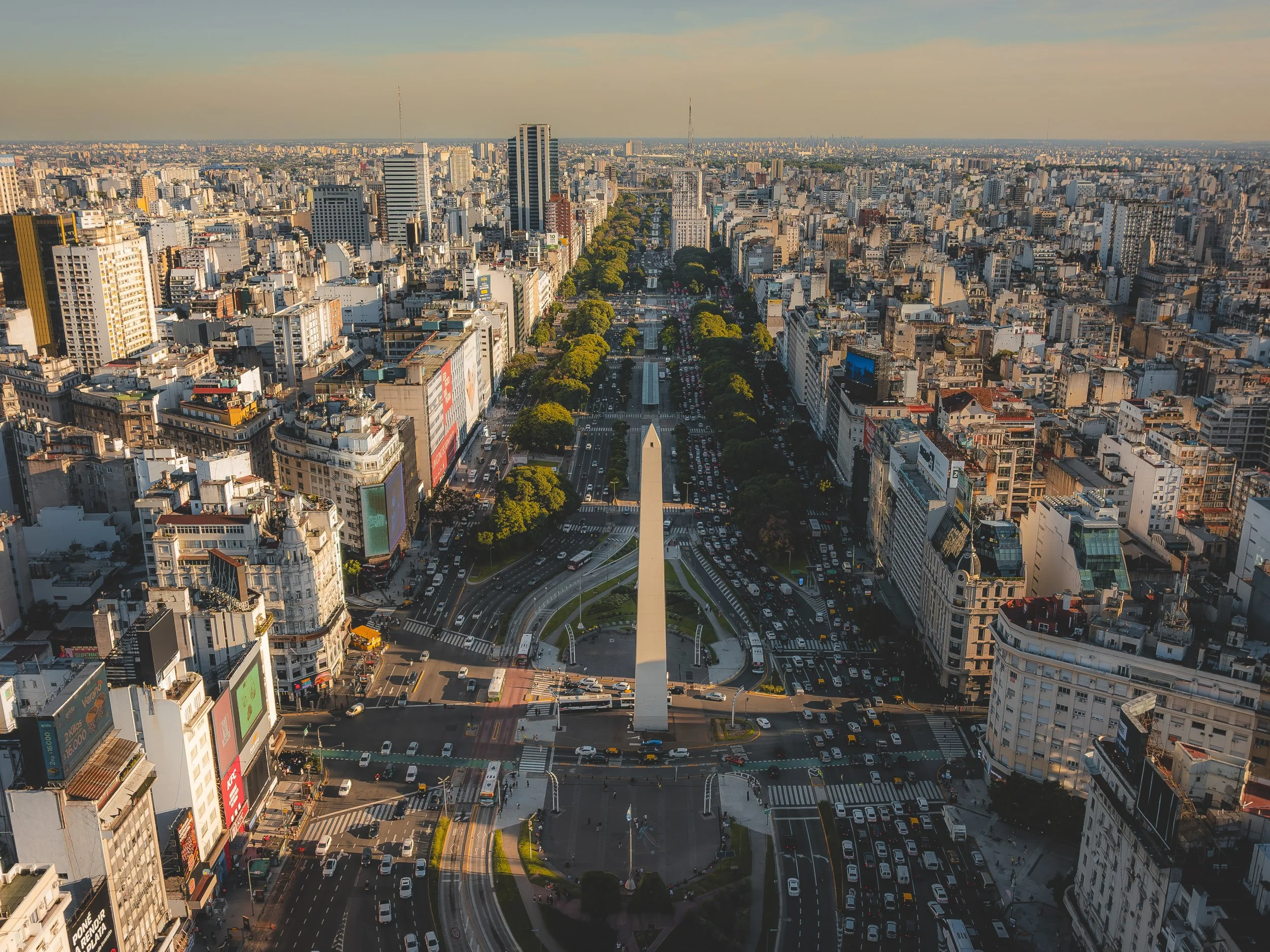 Vista aérea del Paseo de la Reforma en Ciudad de México con el Monumento a la Independencia en el centro, rodeado de edificios altos y calles congestionadas.