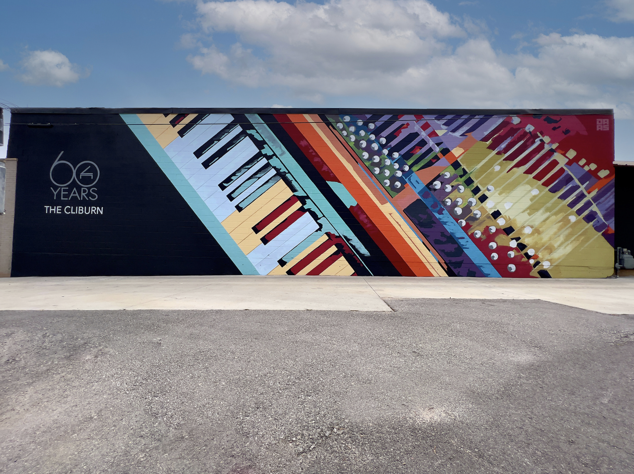 Work by the artist DAAS, Colorful mural on a building wall featuring abstract piano keys and musical elements with the text '60 Years The Cliburn' in white.